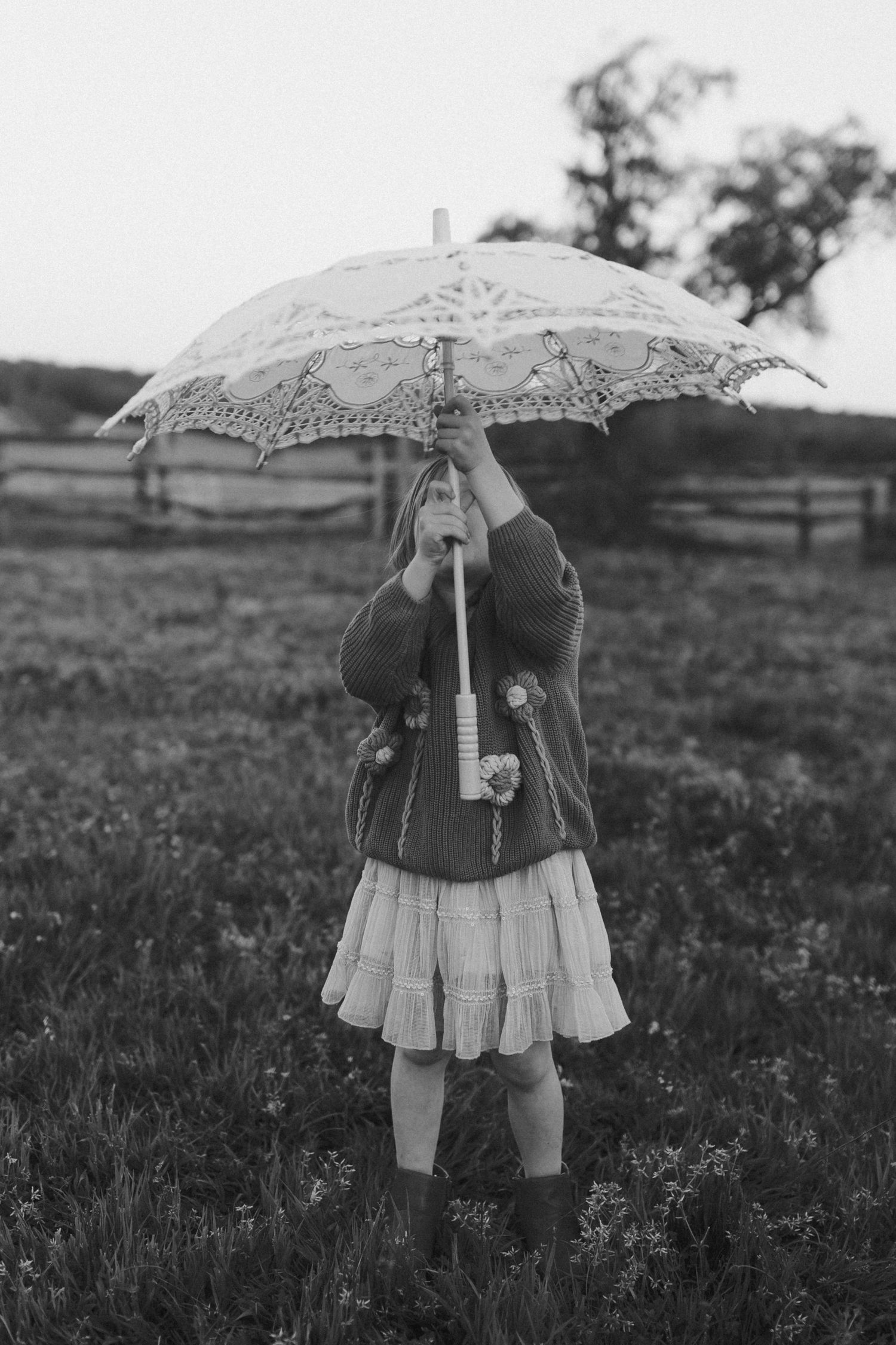 A sequence of vintage black and white photographs showing a figure with a decorative parasol in a field.