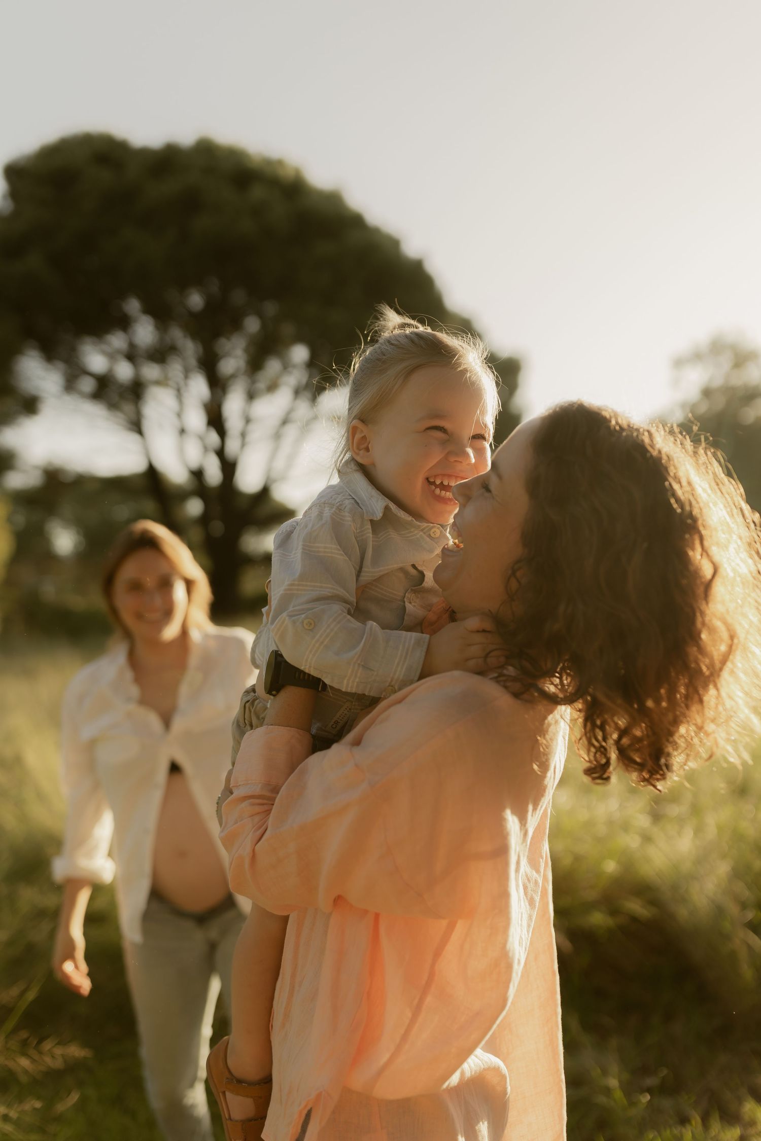 Sweet family interactions photographed during golden hour in a natural outdoor setting.