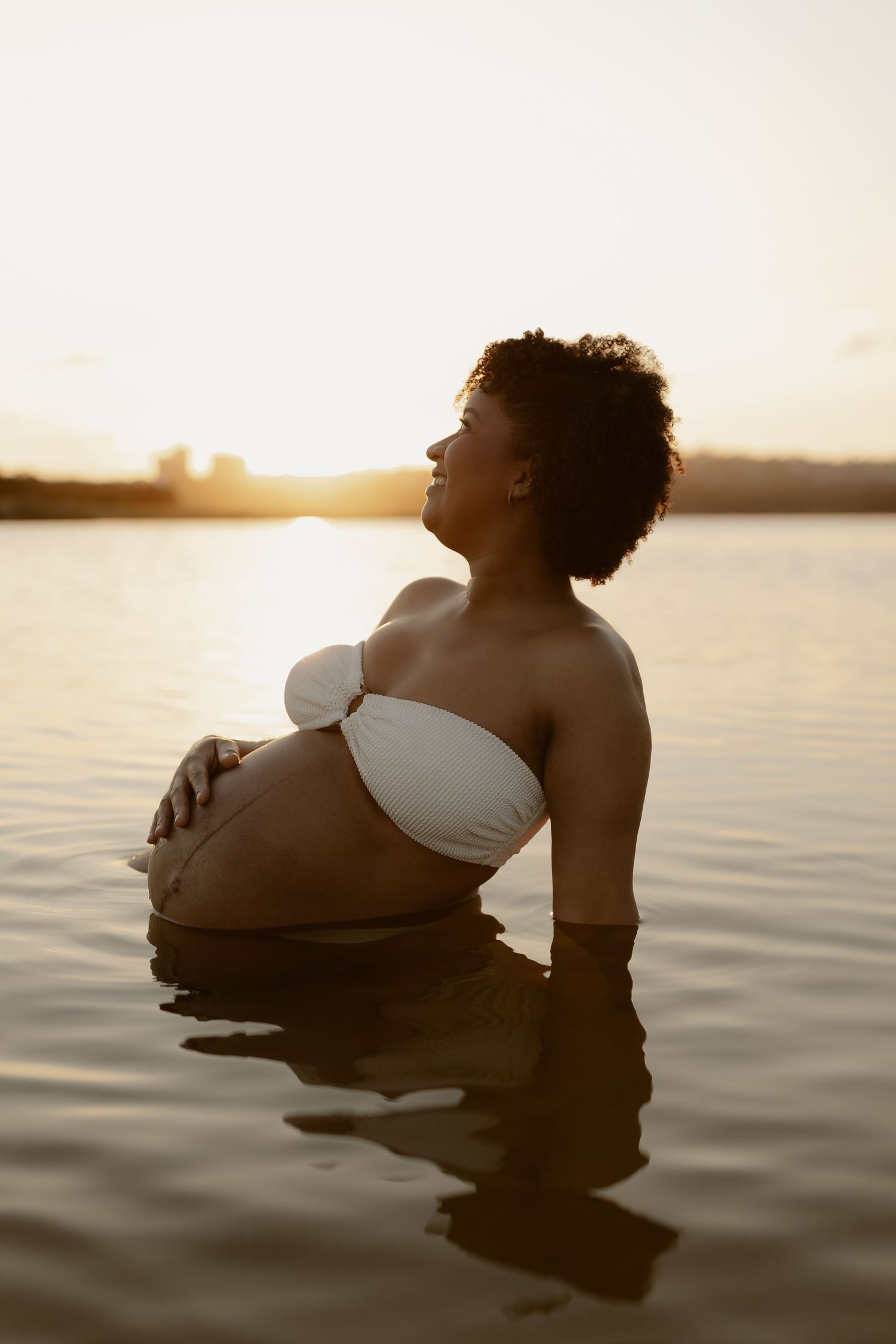 Silhouette of a person floating in calm water at sunset creating a peaceful and serene atmosphere.