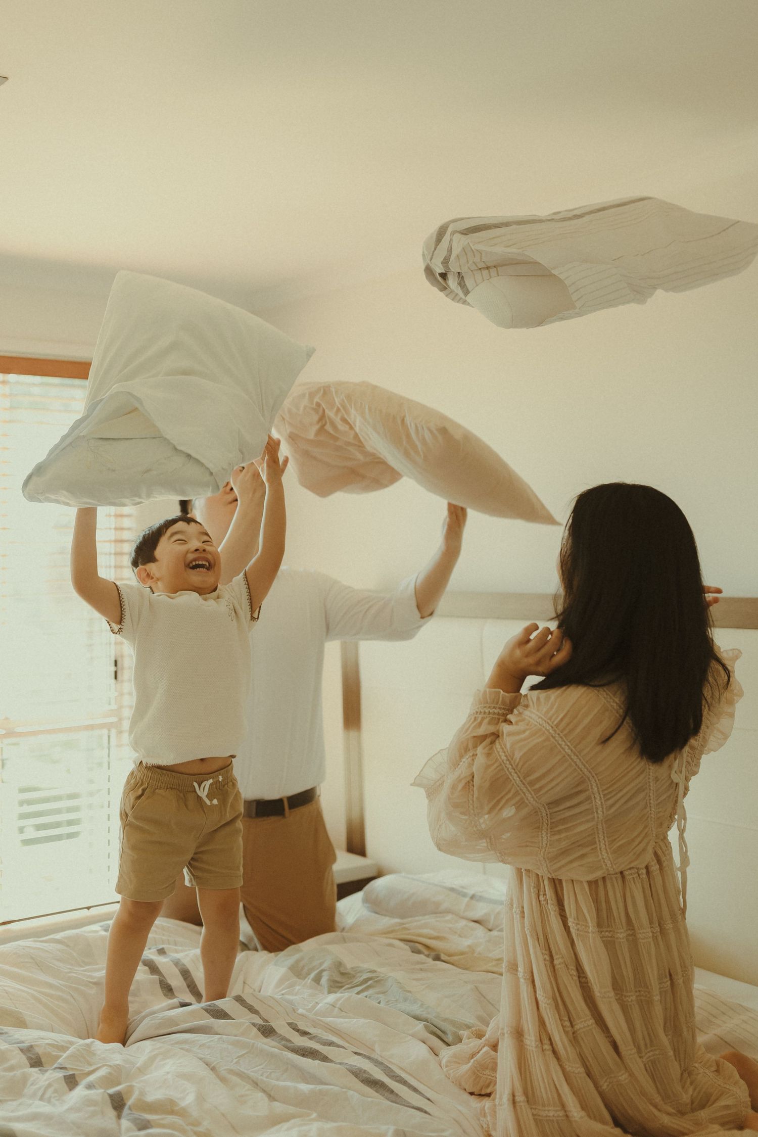 A series of photos showing someone stretching and getting out of bed in the morning with white bedding and soft lighting.
