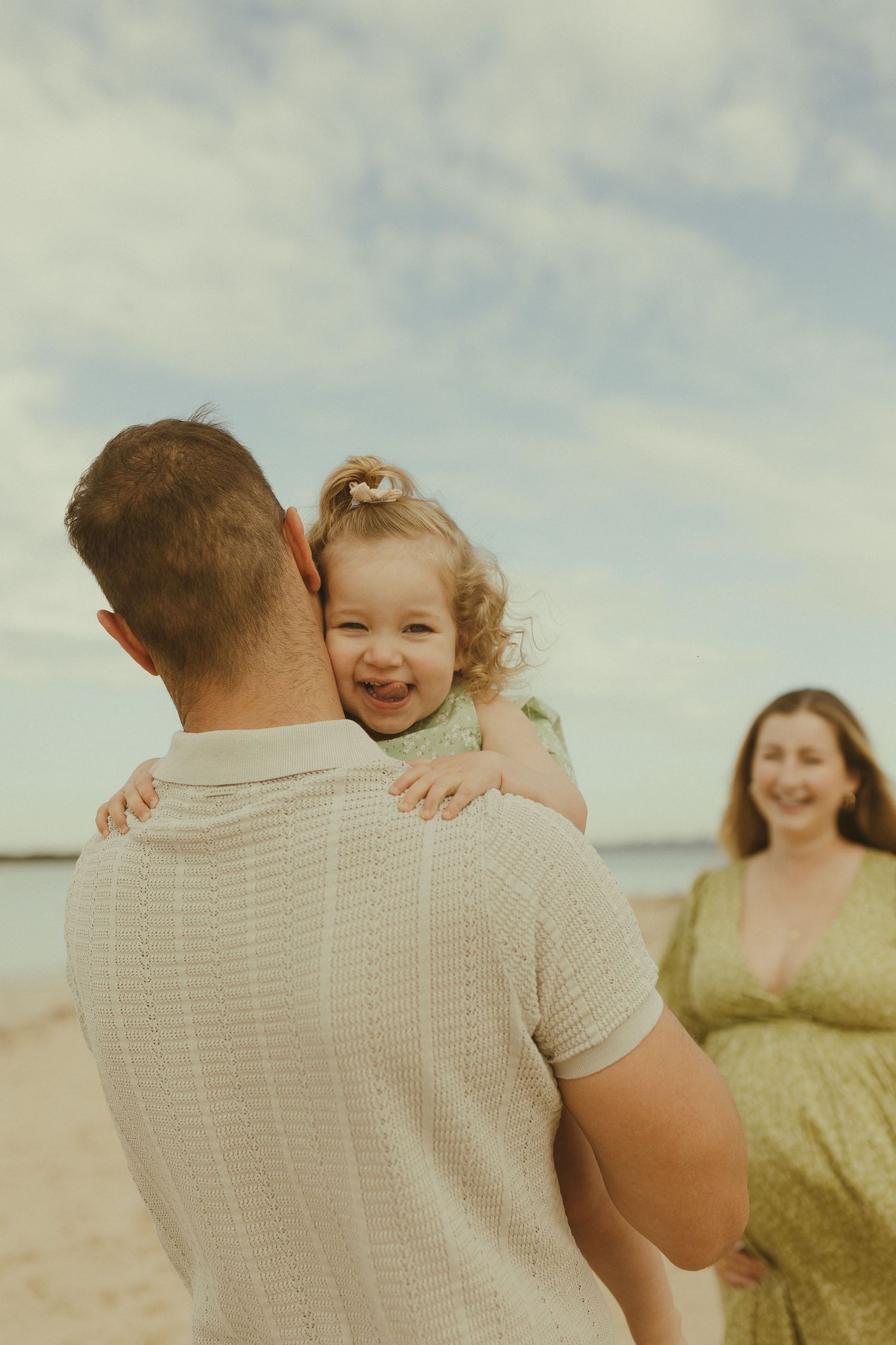 A joyful family moment captured in a series of candid photos at the beach on a cloudy day.
