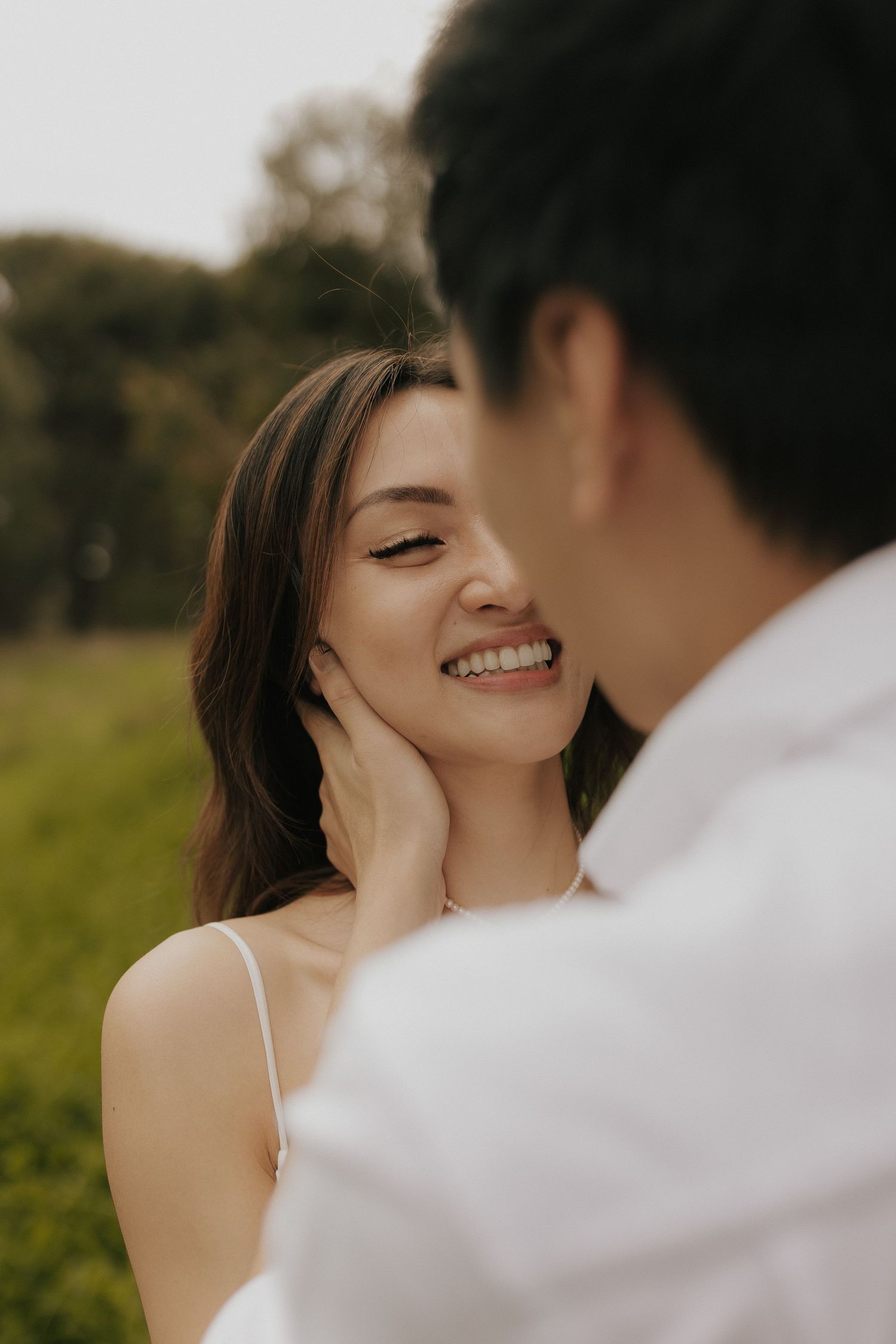An intimate couple shares tender moments during a romantic outdoor photo session at sunset.