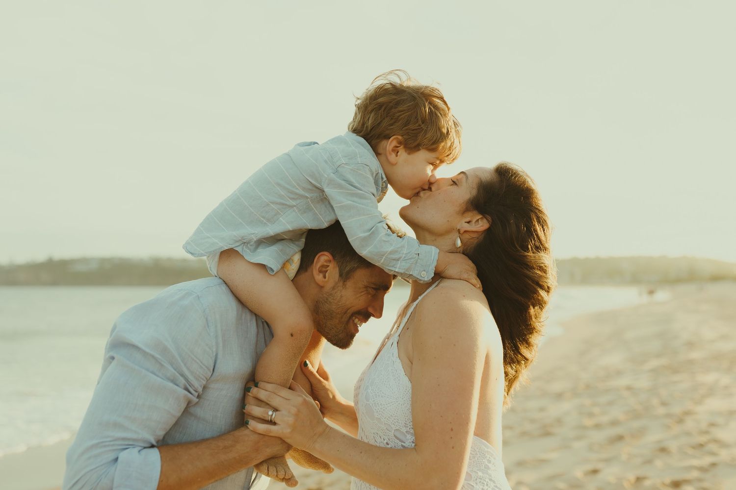 Romantic beach portrait session with couple in light blue and white attire.