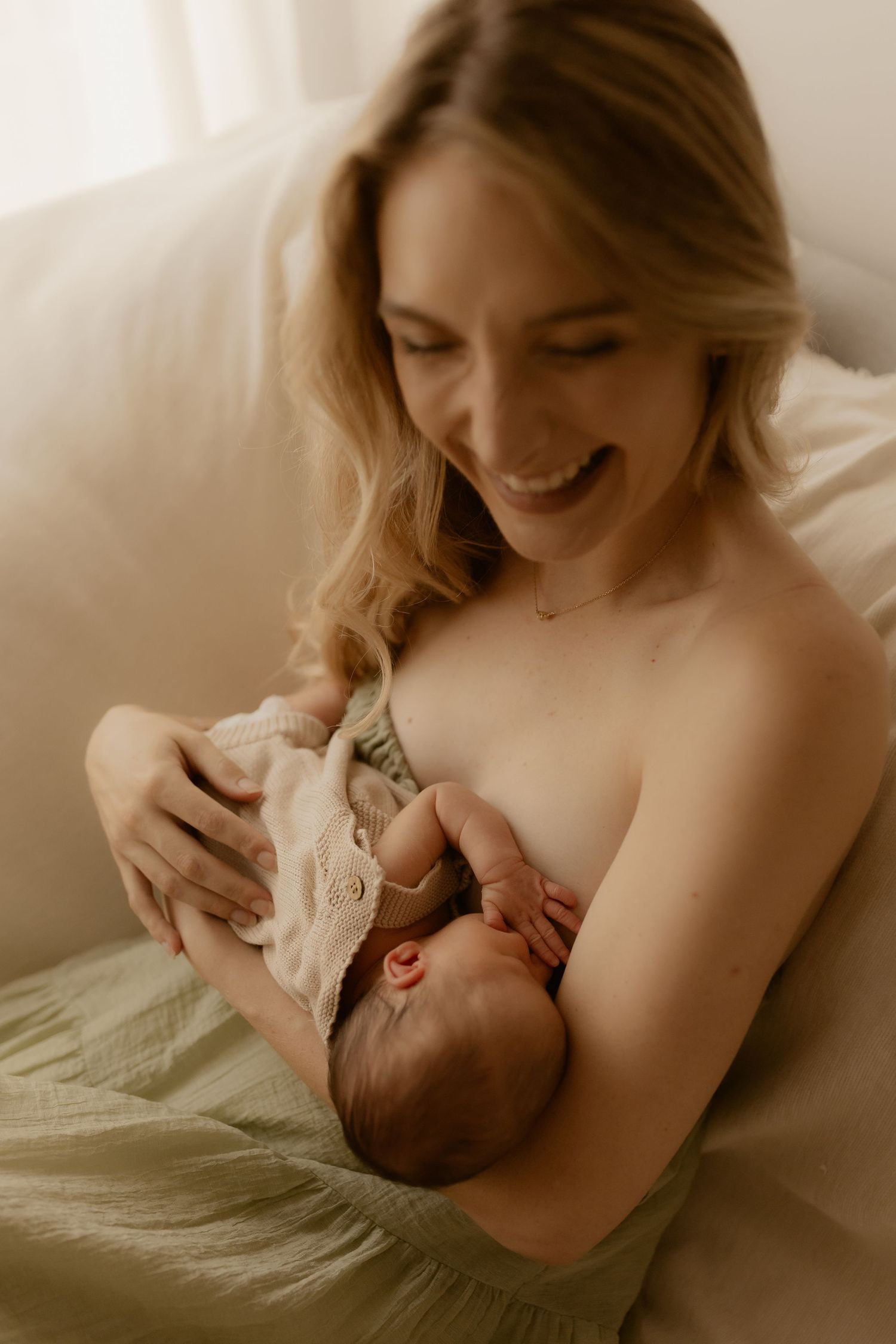 Tender nurturing moment between mother and newborn during feeding time in natural light.