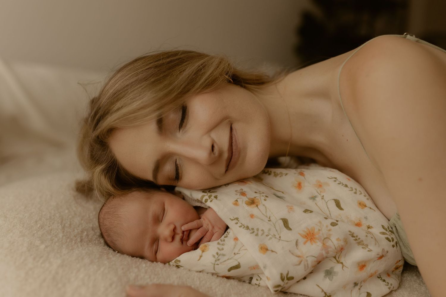 Peaceful moments captured of parents and baby resting together on white bedding.