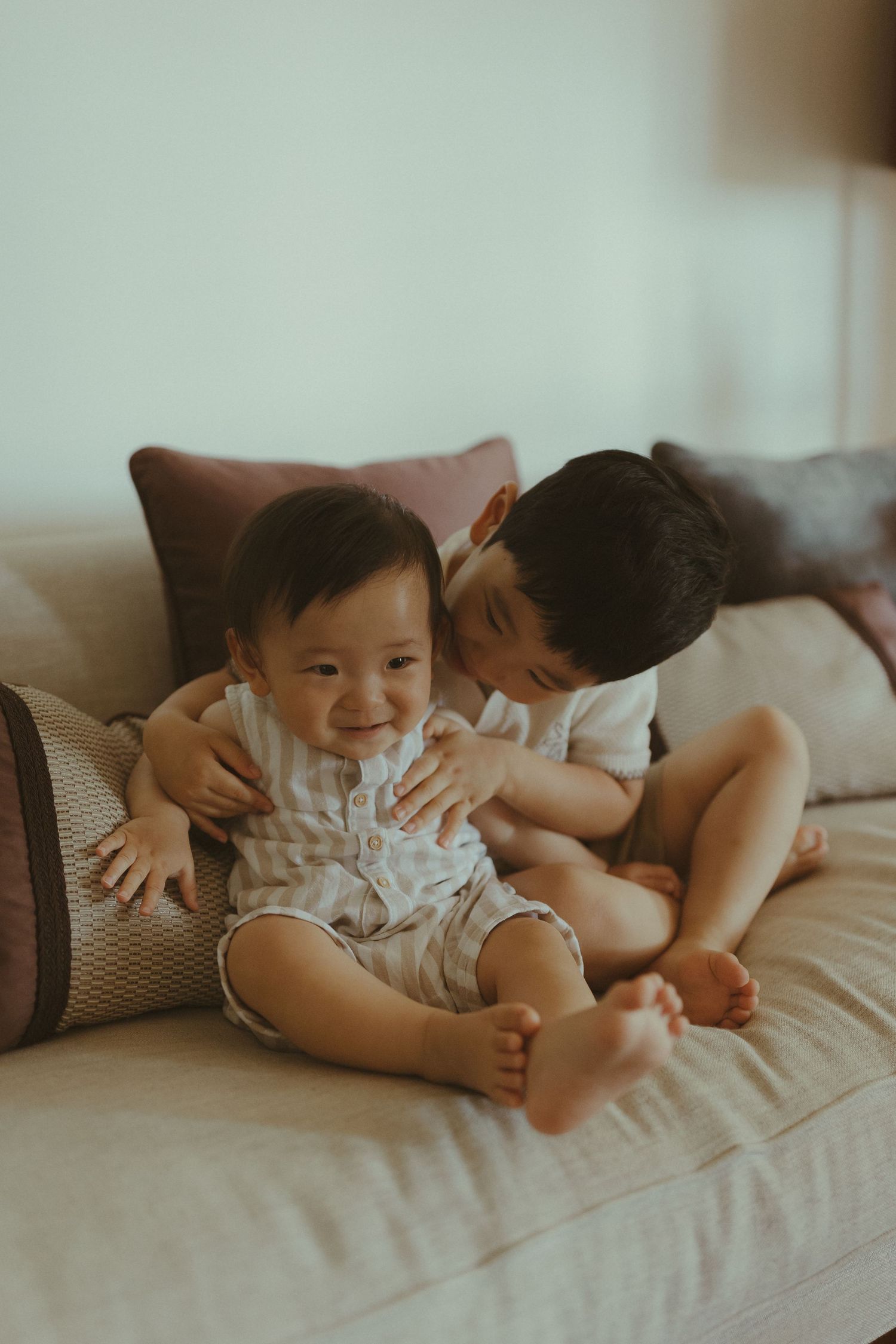 Tender moment shared on a cozy gray couch during playtime.