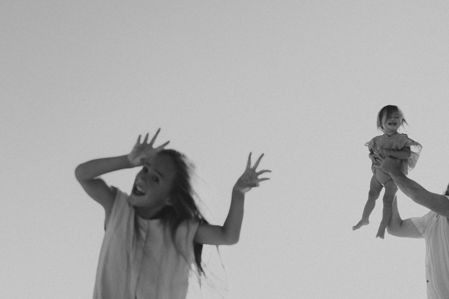 Silhouetted figures dance expressively against a light background creating an artistic movement sequence.