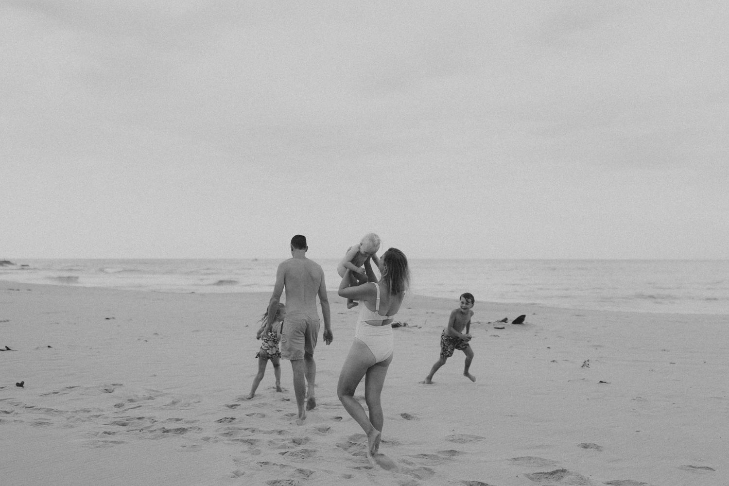 Black and white photographs show people and dogs enjoying leisure time at a sunny beach.