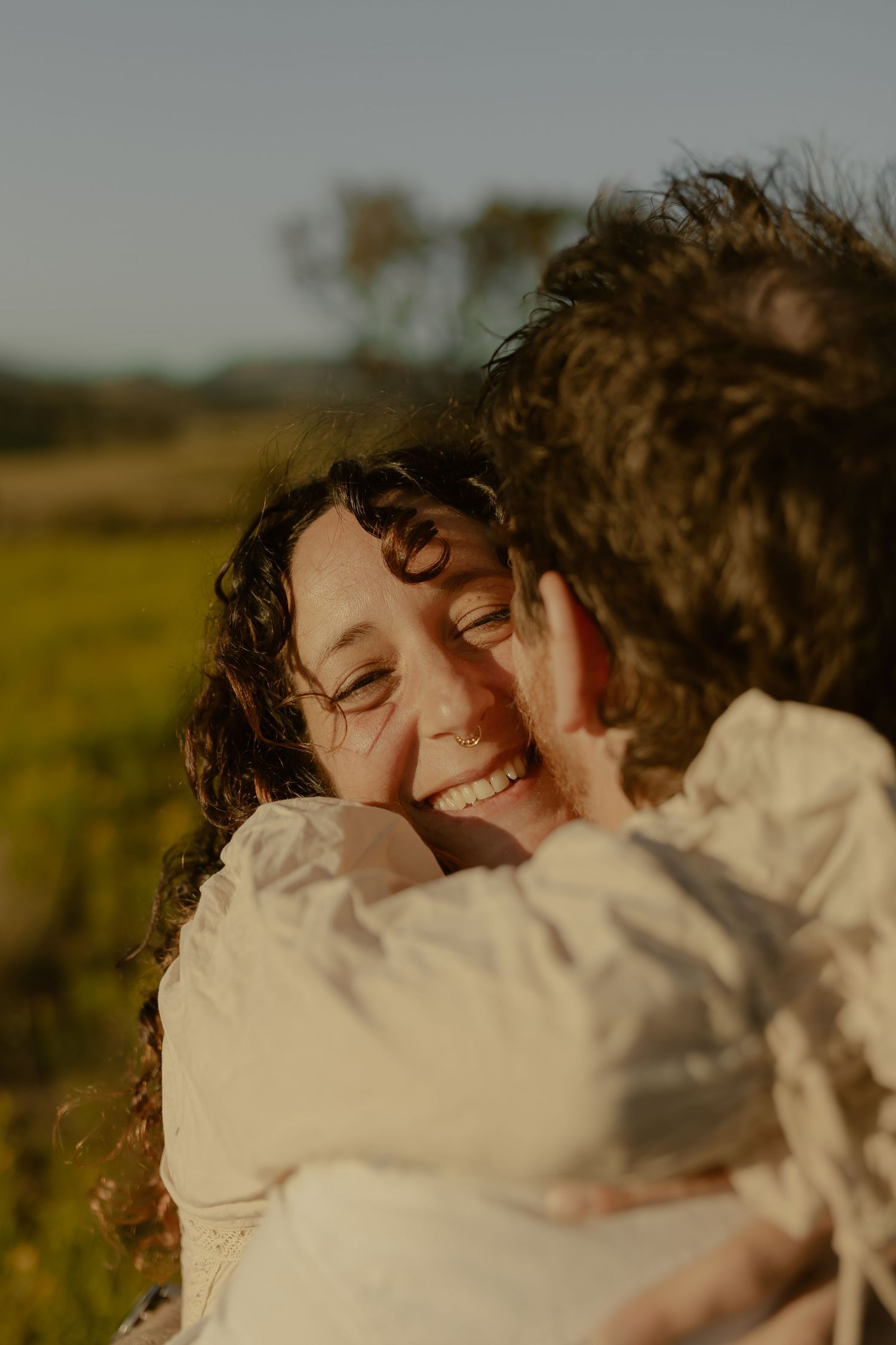 An intimate close-up moment shared between two people in warm golden sunlight.