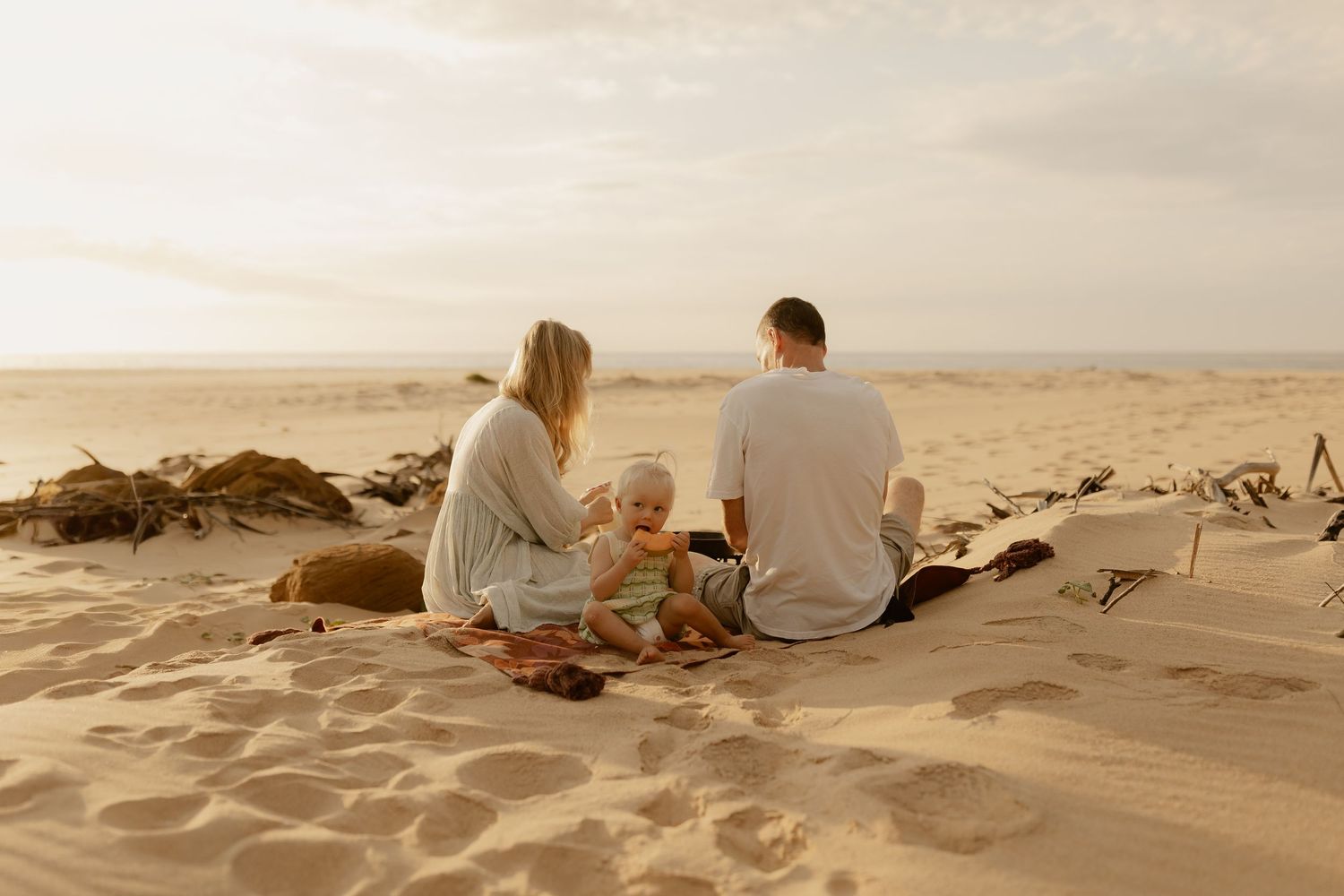 A wide view of a beach picnic setting with sand dunes stretching to the horizon.