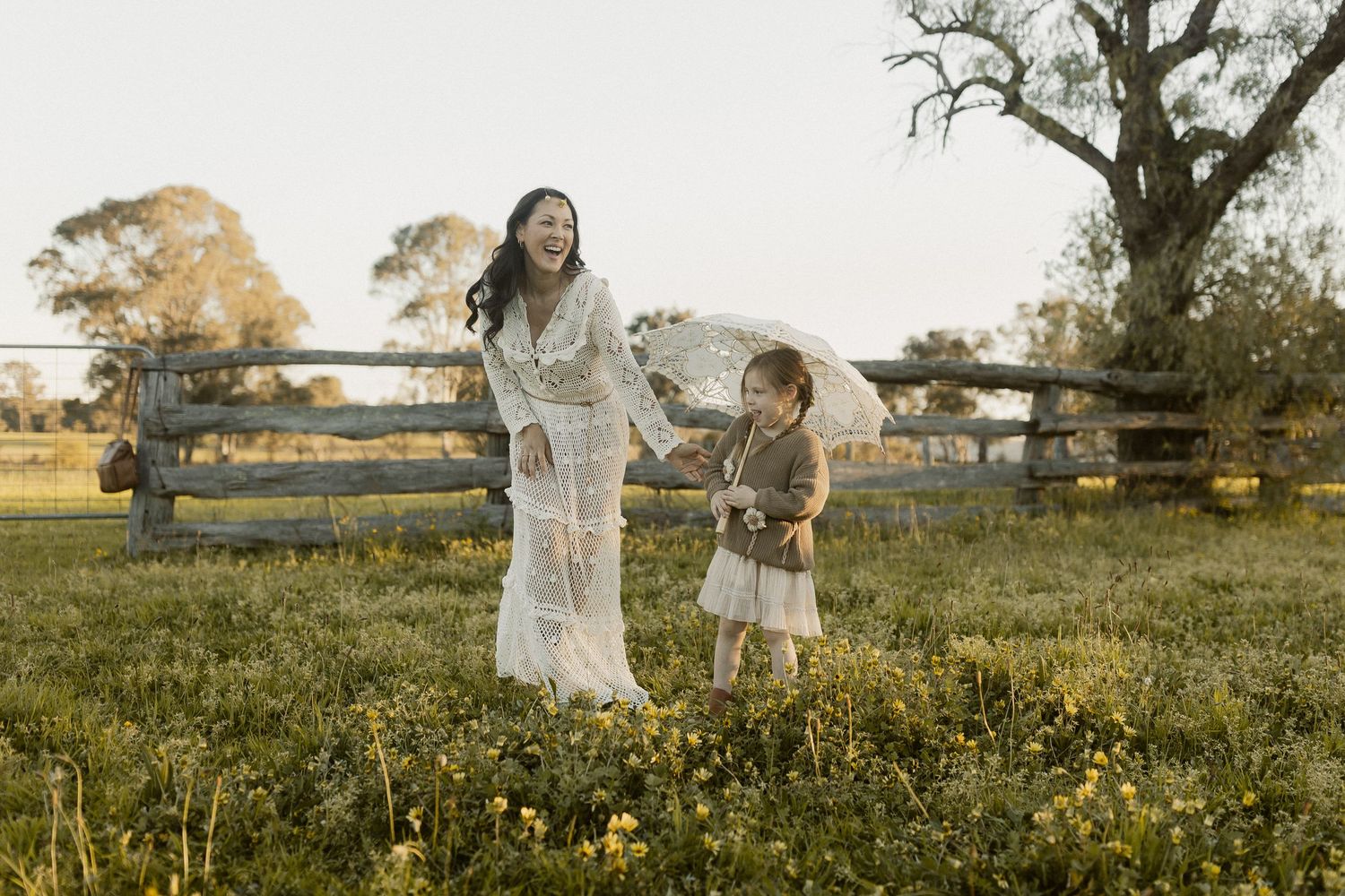 People enjoy playful moments in a sunlit field of yellow wildflowers during golden hour.