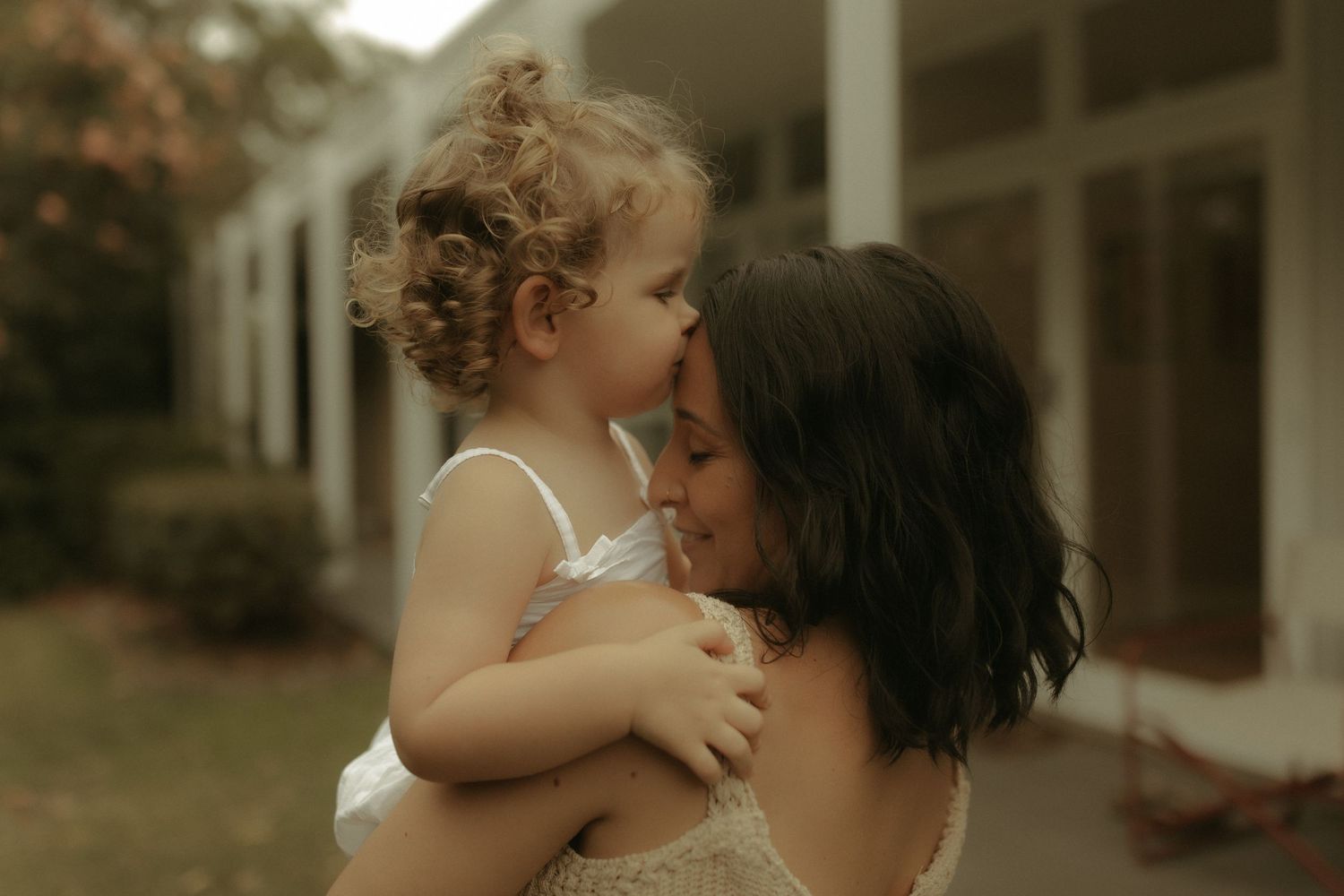 Tender moment shared between two people in a sunlit room with soft, dreamy lighting.
