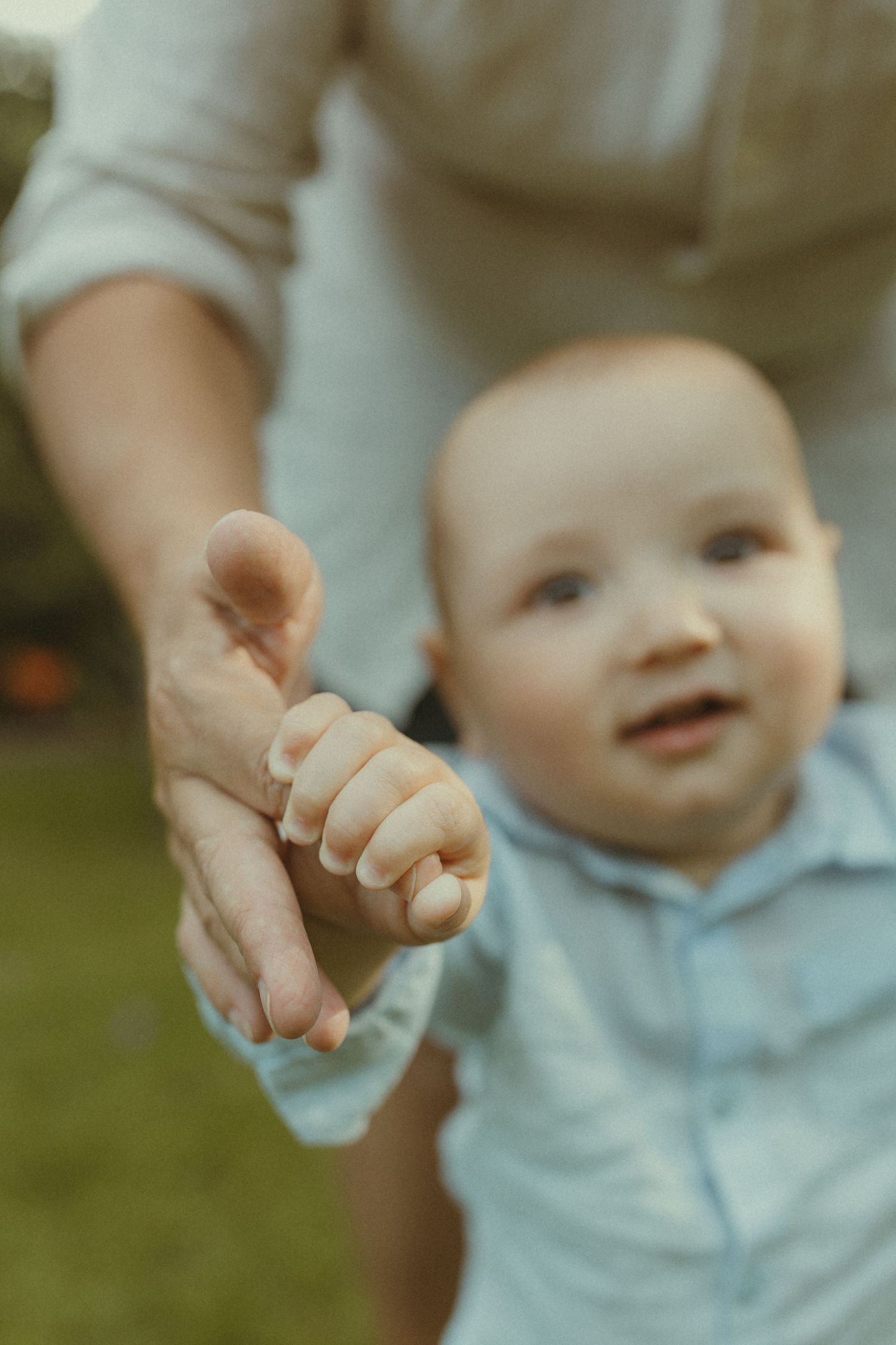 Close-up shots of a baby's tiny hand reaching out while wearing a light blue outfit.