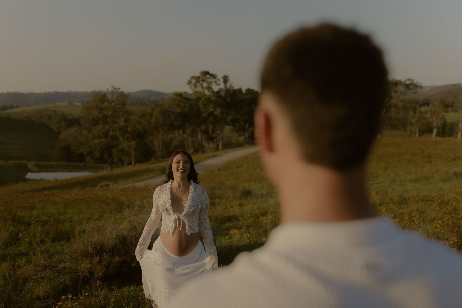 A romantic scene unfolds in a field of wildflowers during golden hour.