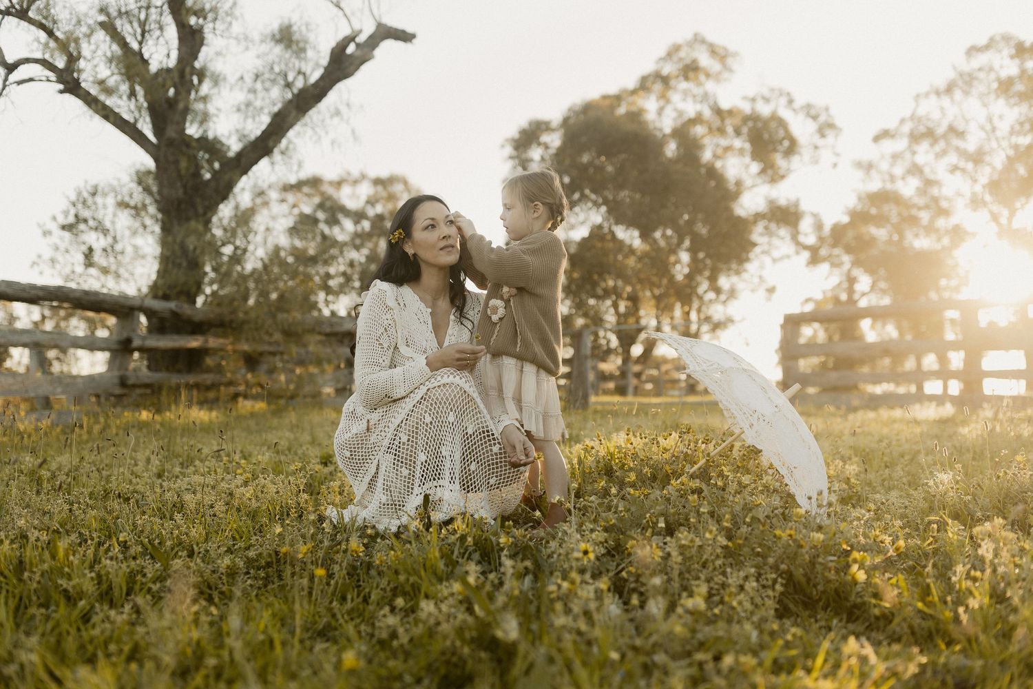 A white floral dress flows in the golden afternoon sunlight as a figure twirls in a grassy meadow.