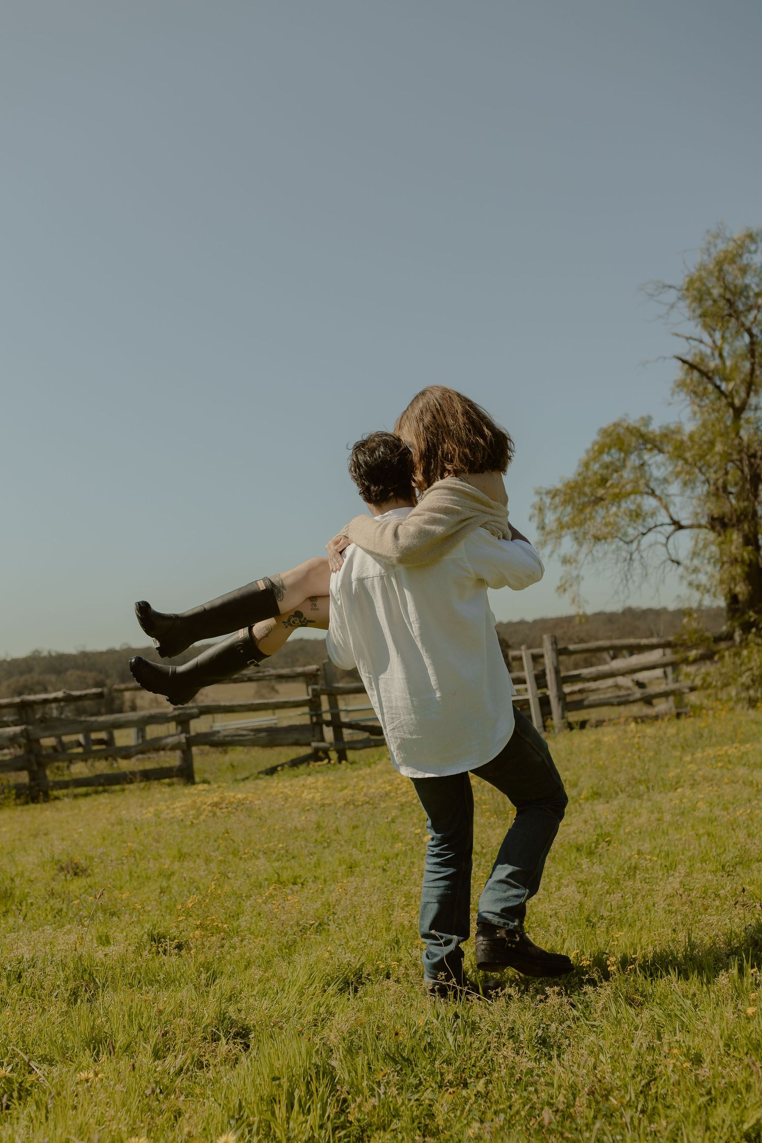 Playful spinning dance sequence in a sunny field with rustic fence backdrop.