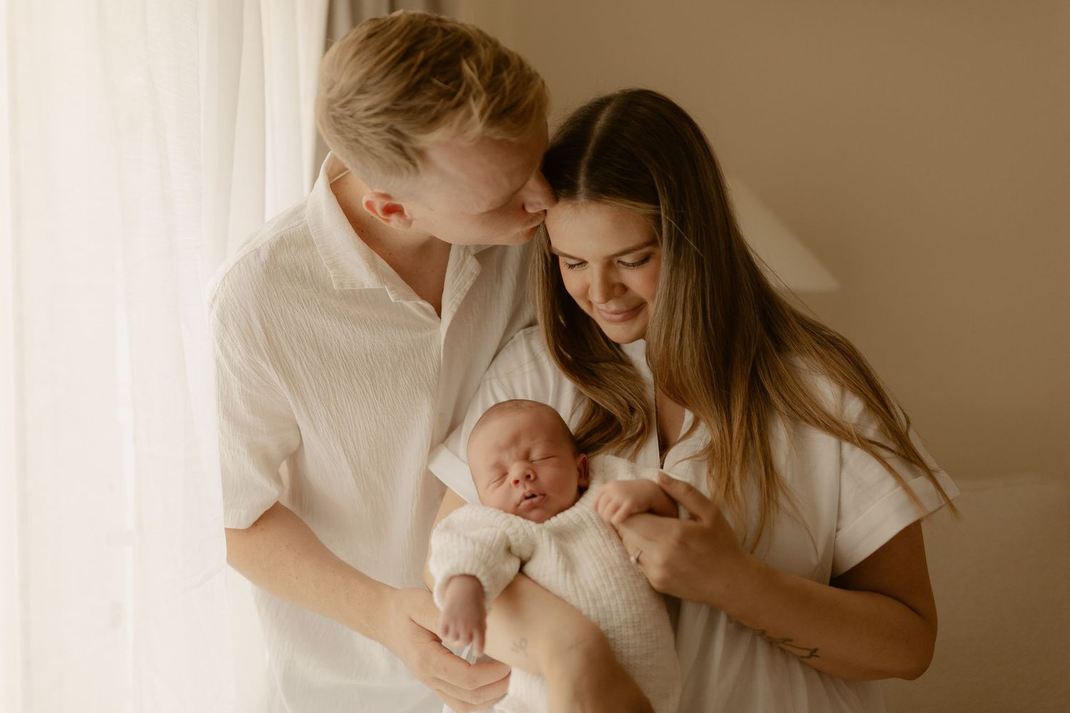Warm toned lifestyle photo showing tender family moment in natural light.