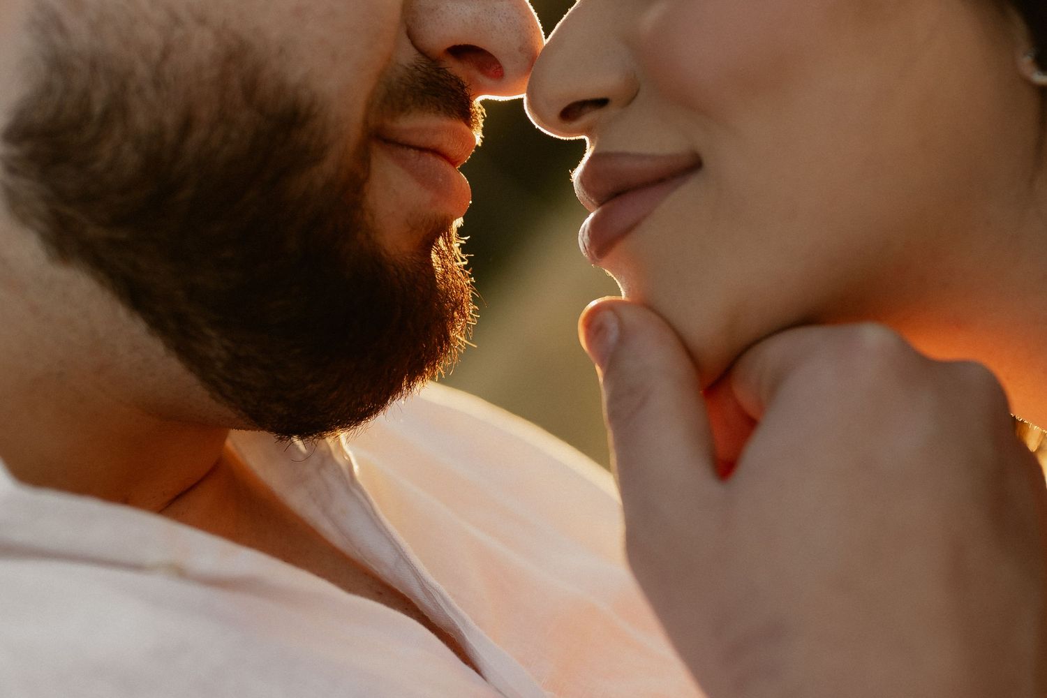 Close up profile view of couple sharing intimate moment at golden hour.