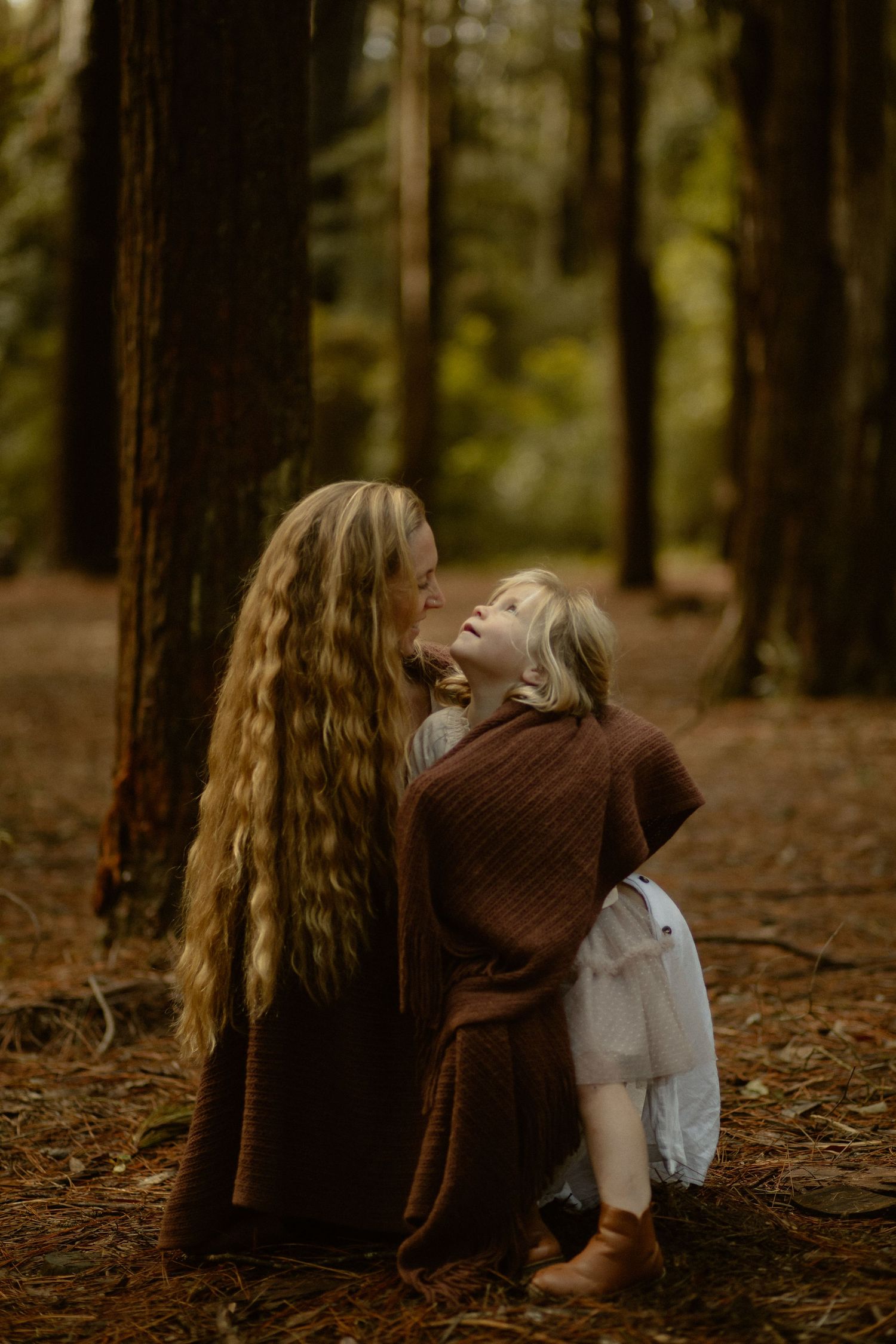 Two people sharing a joyful moment together in a moody forest setting with autumn colors.