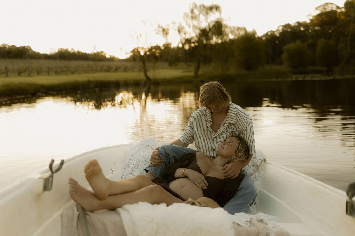 People relaxing on a boat in tranquil waters during sunset.