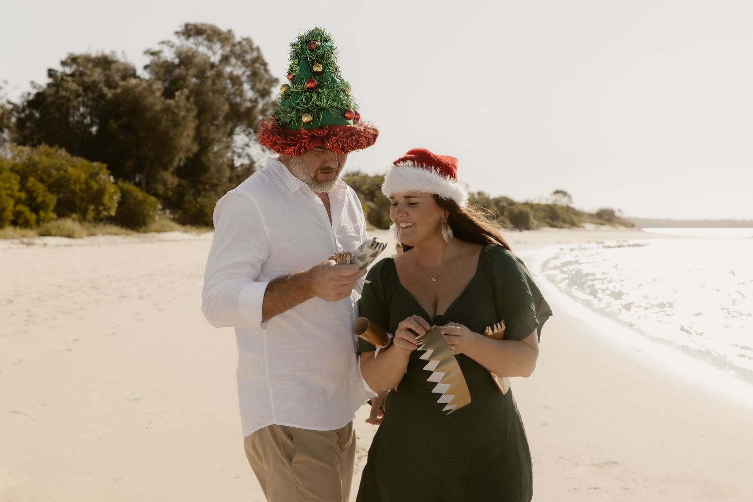 Holiday-themed beach photo with family wearing festive accessories.