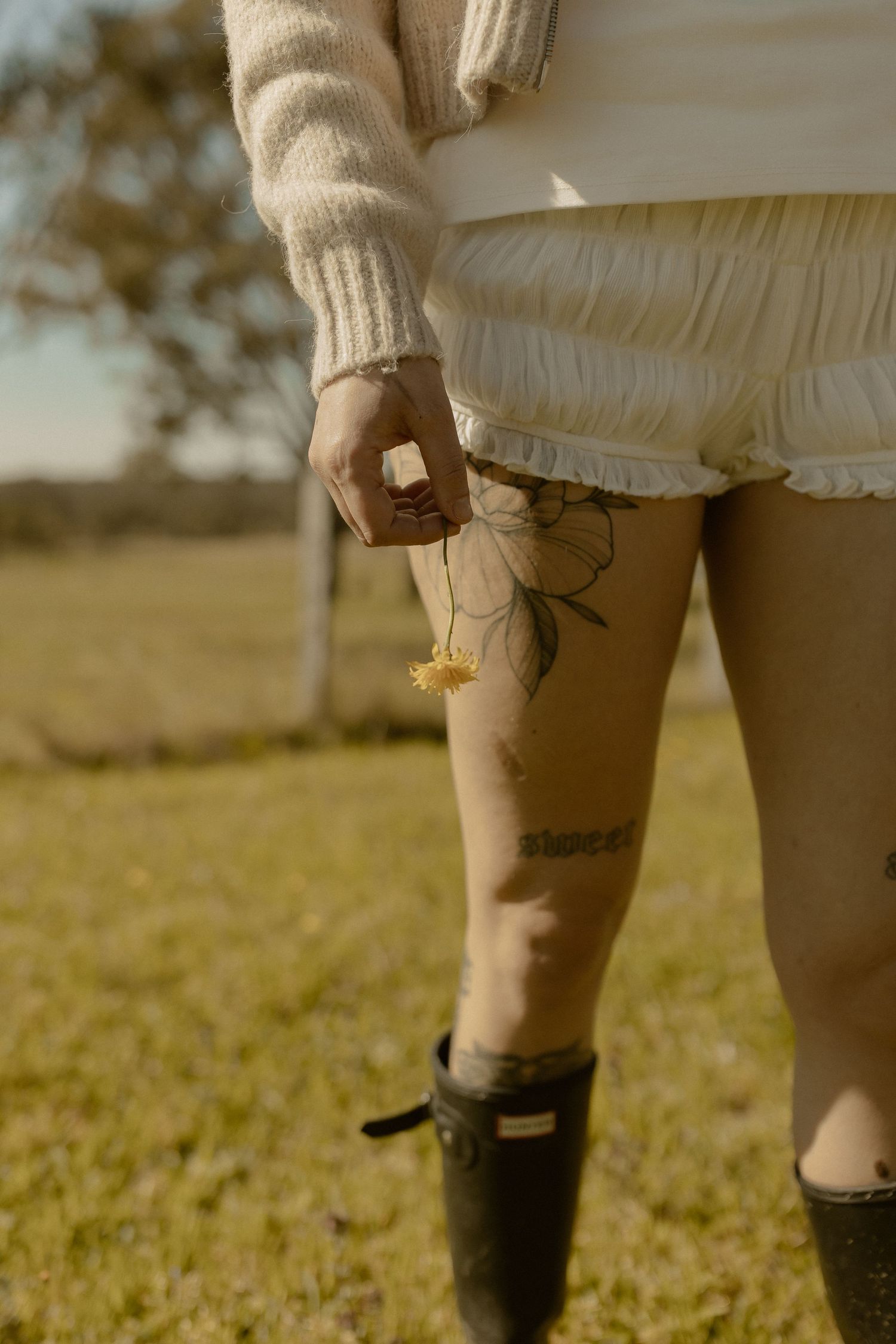 Close-up view of legs showing rustic boots and antique-style clothing in an outdoor setting.