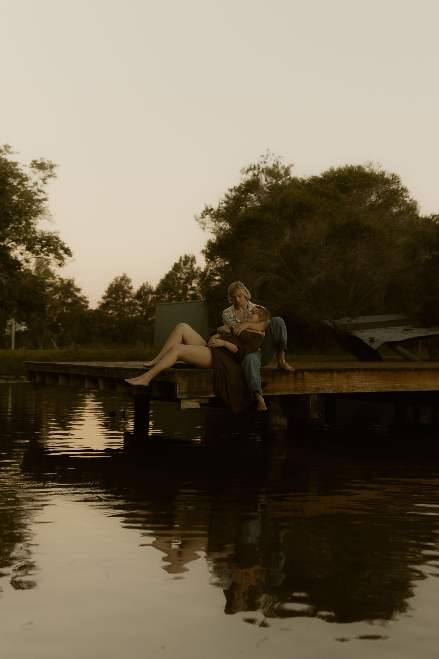 Peaceful lakeside moment captured on wooden dock during golden hour.
