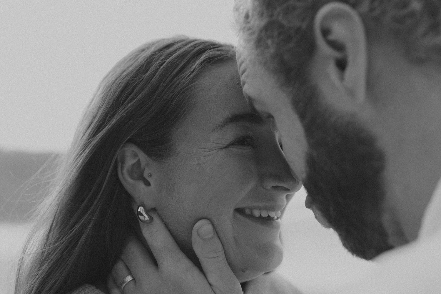 Intimate black and white close-up capturing a tender moment between two people.