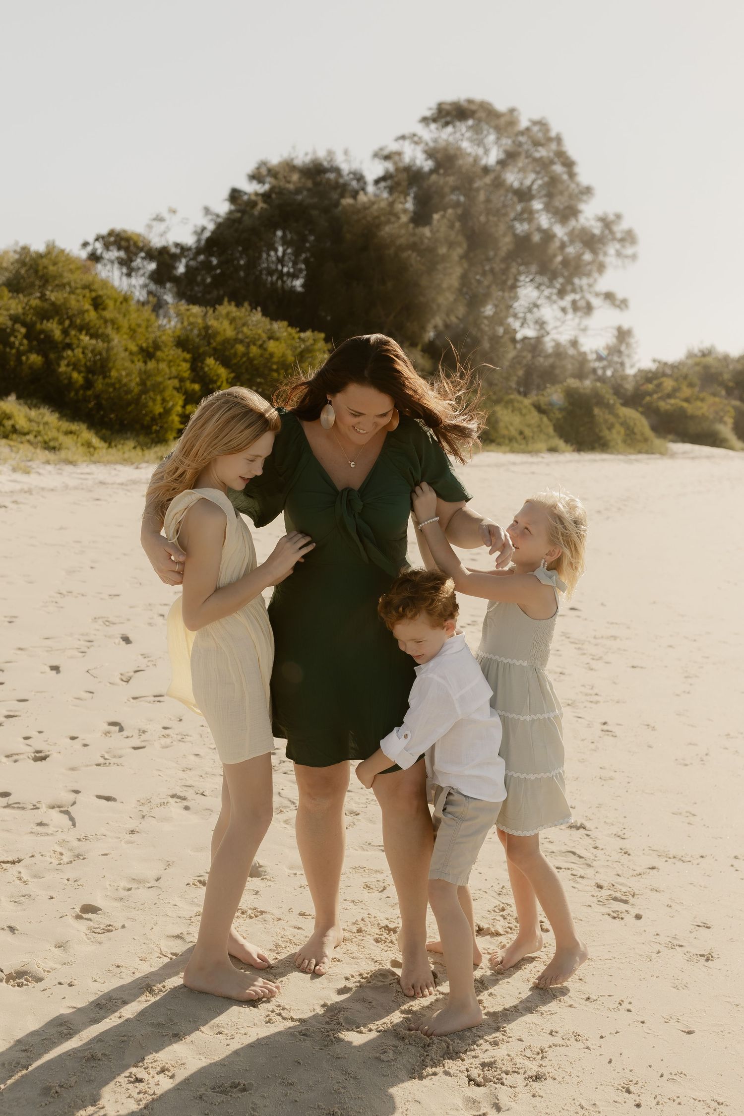 Group playing and laughing together on a beautiful beach with golden sunlight.