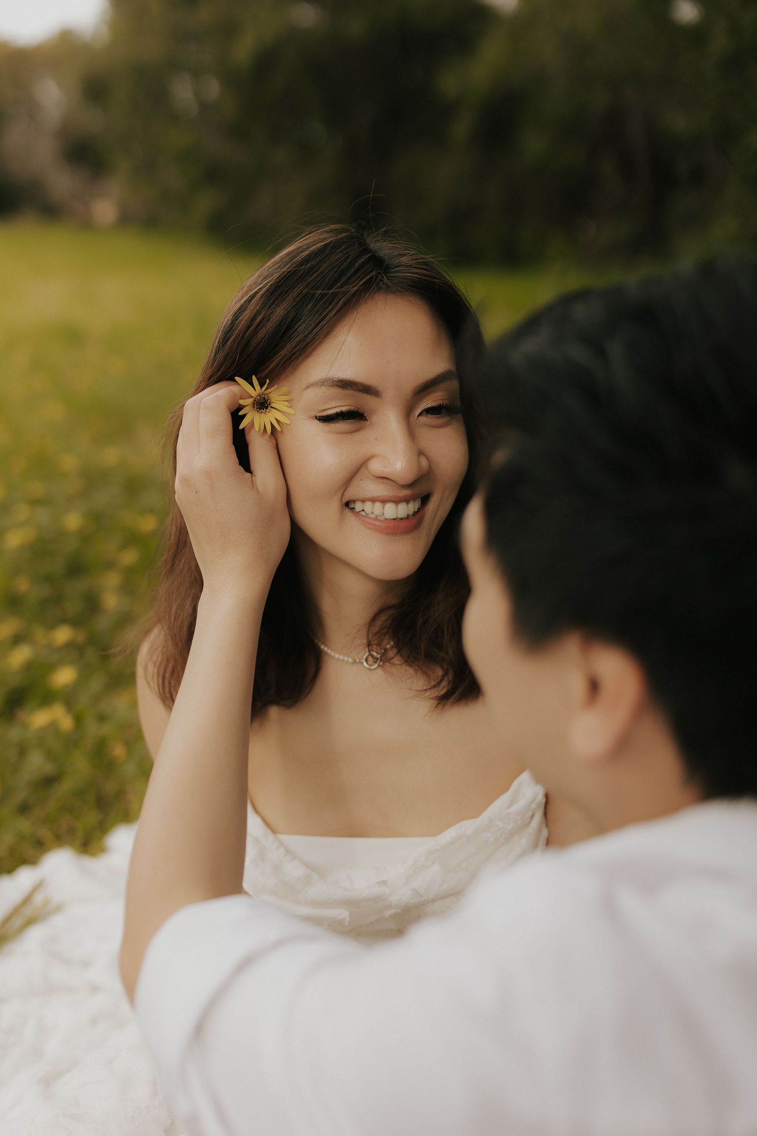 A couple shares joyful laughter during their outdoor wedding photo session.
