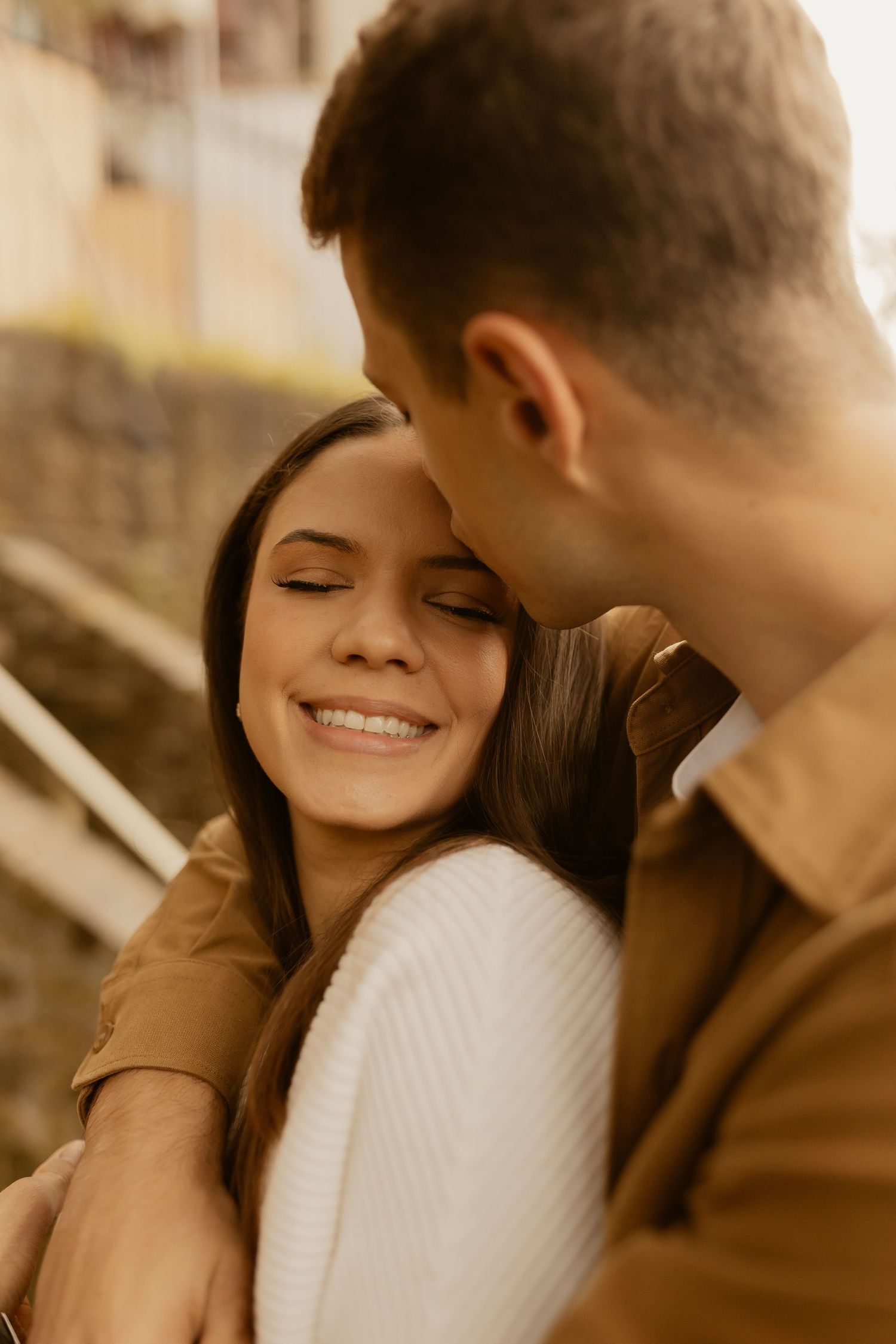 Romantic couple sharing an intimate moment with warm lighting and brown tones.