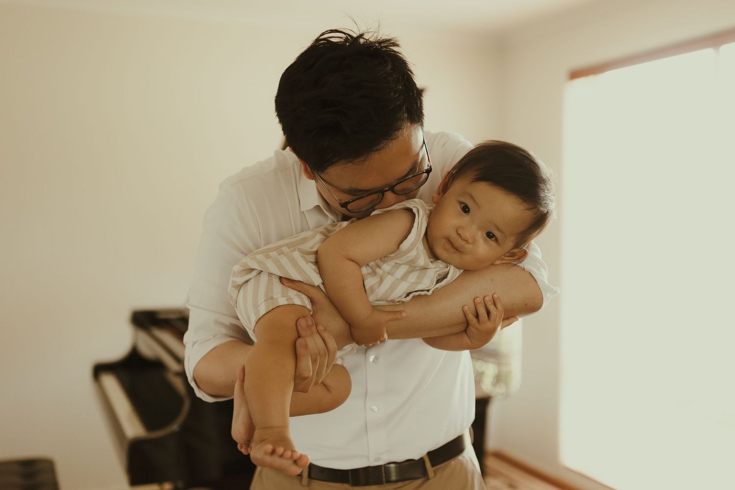 A tender black and white photo series showing intimate parent-child moments during a lifestyle photography session.