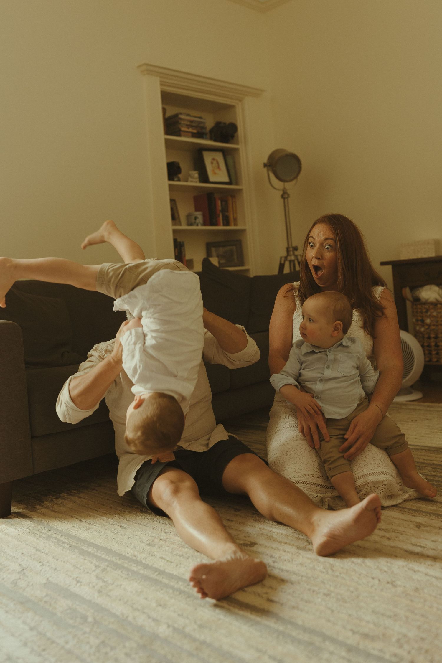 A playful sequence of movement on a carpeted floor showing interaction between two figures in white clothing.