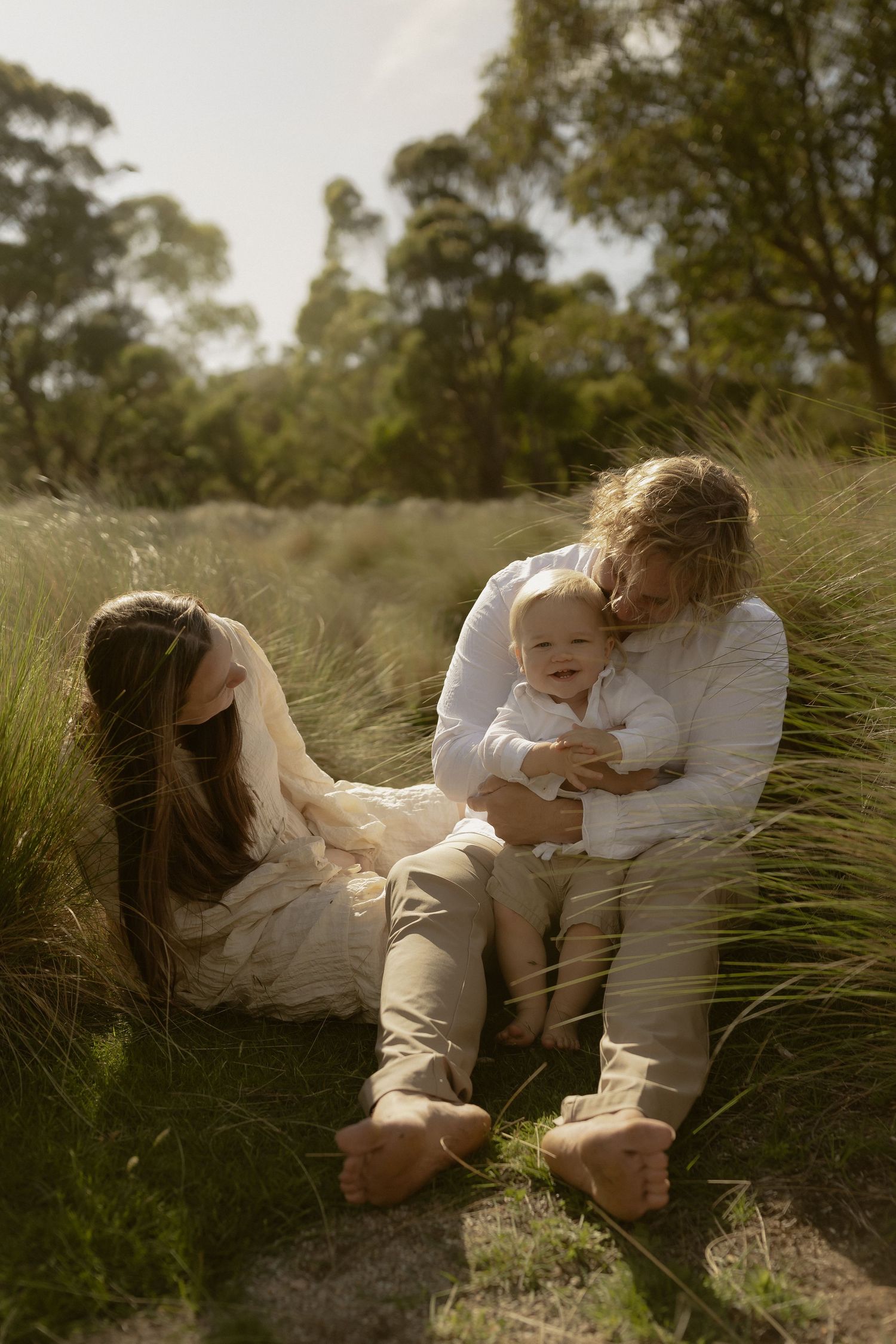 Intimate family portrait set against a backdrop of native grasses in warm afternoon sunlight.