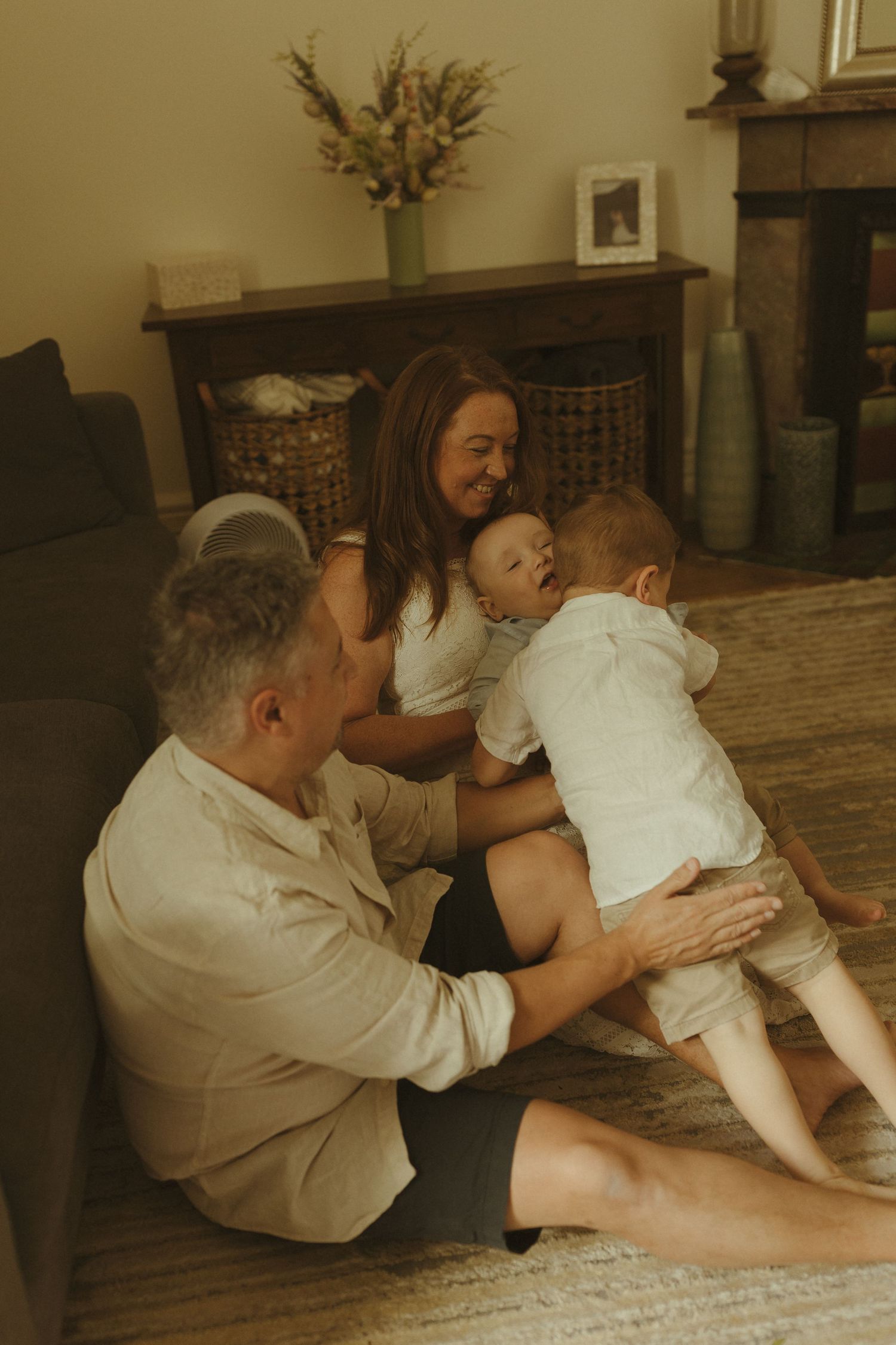A series of sepia-toned photos showing a tender moment between people sitting on a hardwood floor.