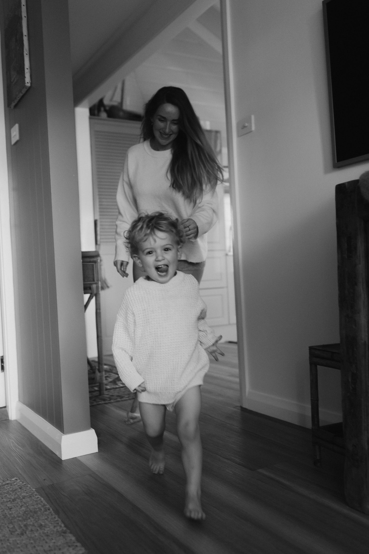 Dancing figures in white clothing create motion blur in a bright hallway.