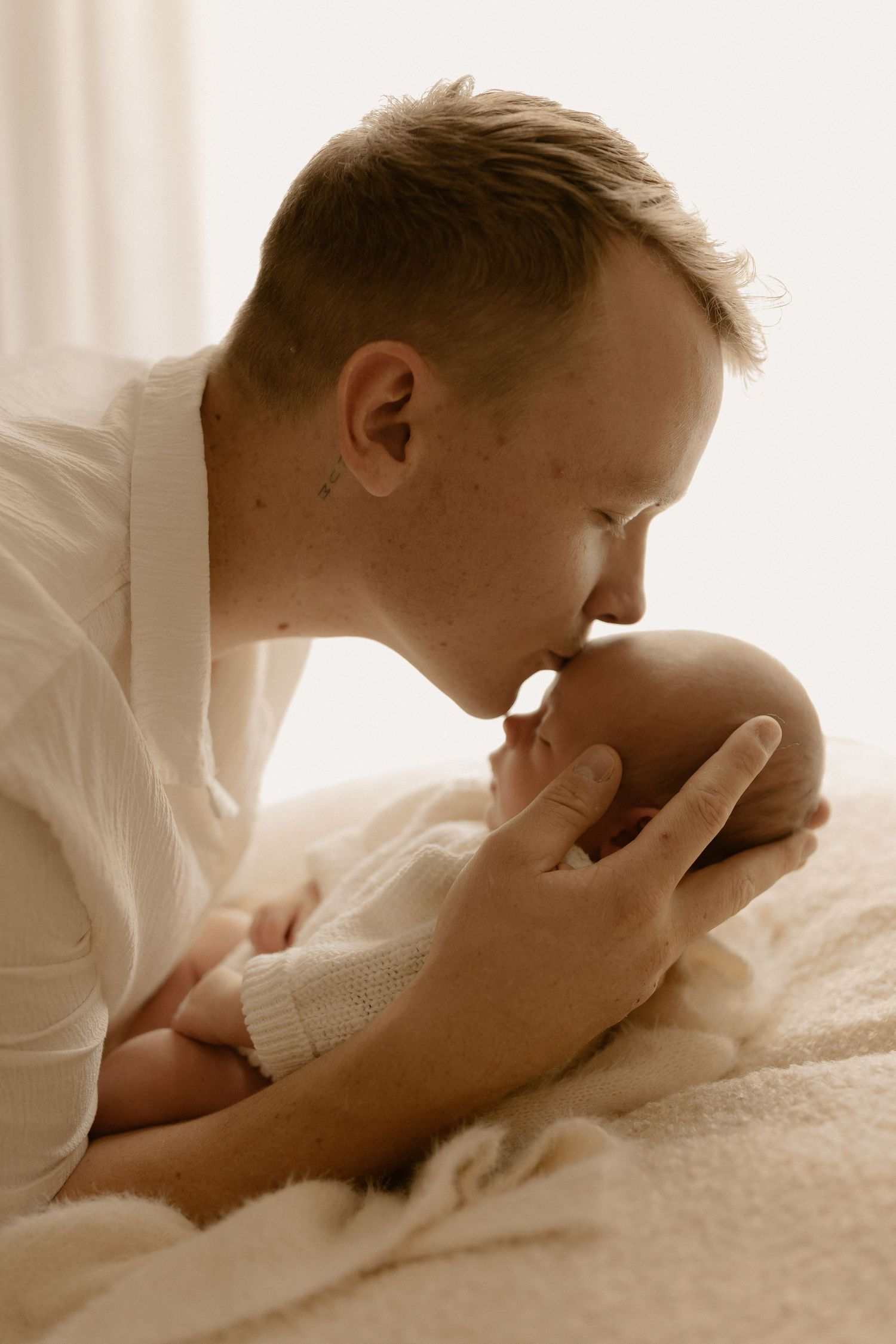 A sepia-toned series of intimate close-up shots showing tender parental moments with a newborn.
