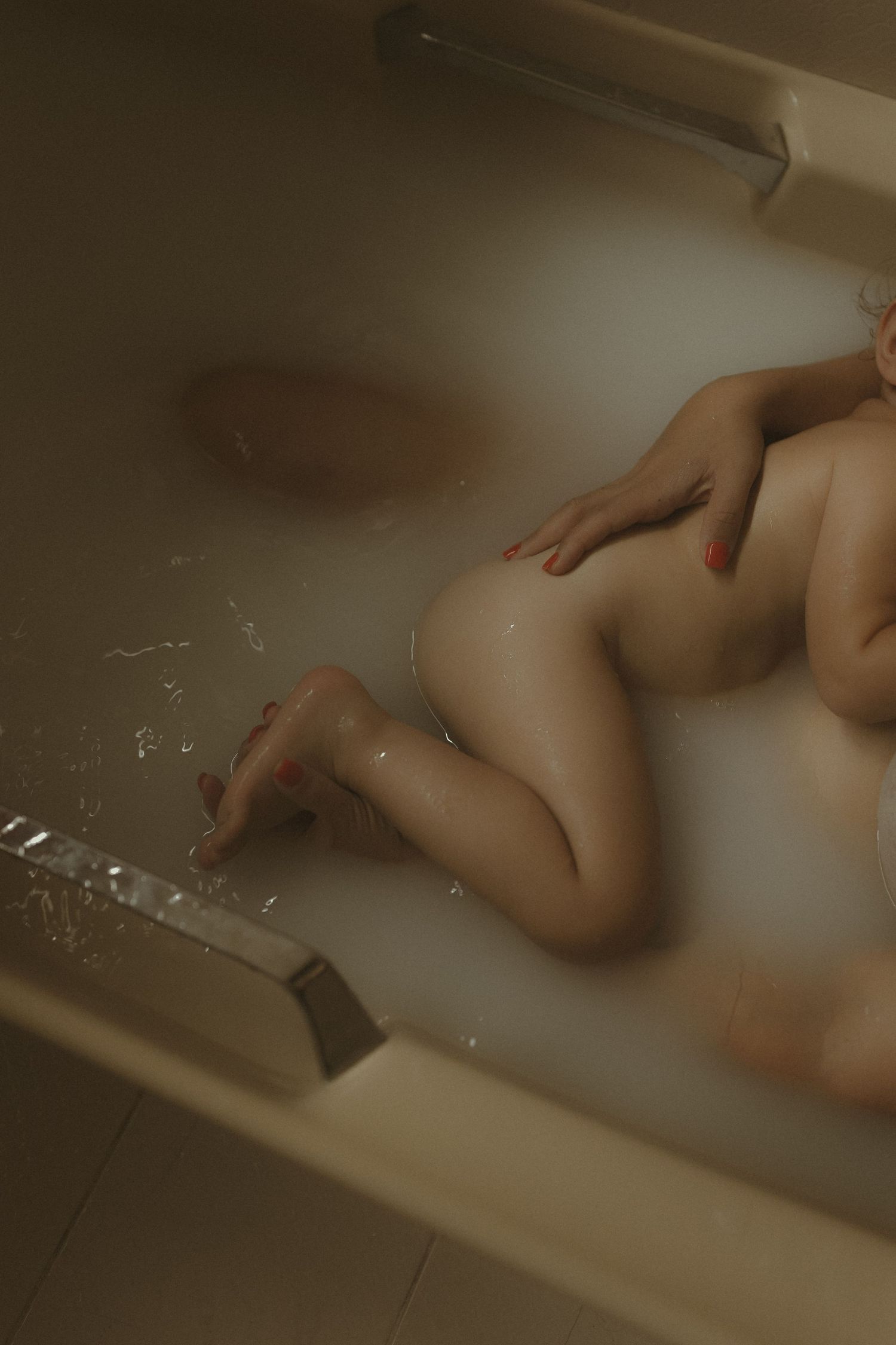 Ethereal bathtub scene with gentle rippling water and muted lighting creating a dreamy atmosphere.