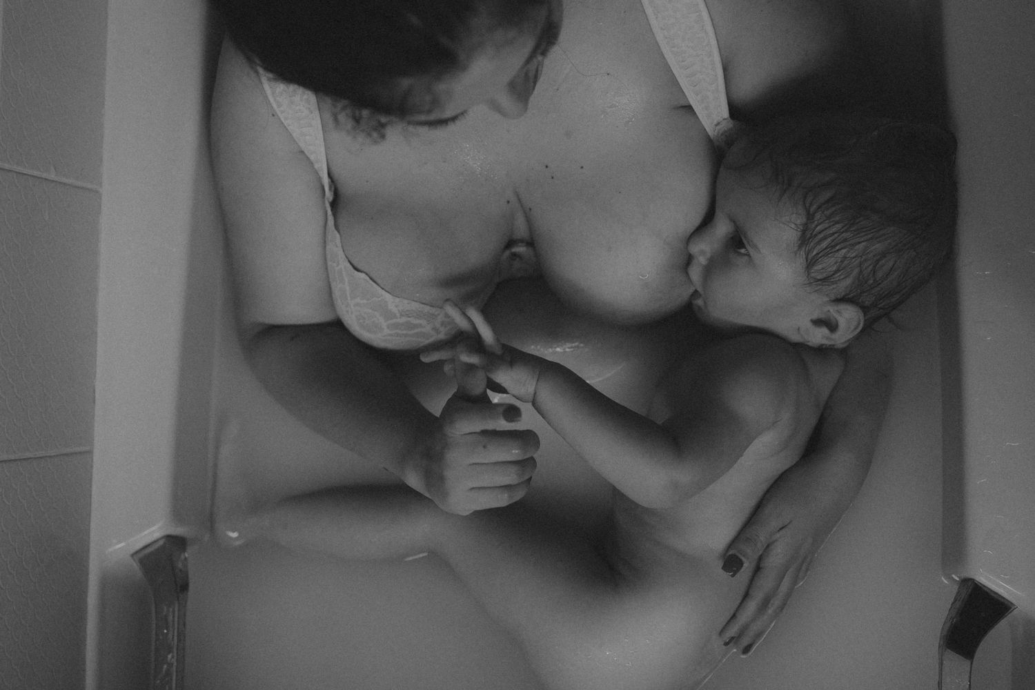 A series of black and white photographs showing tender moments between a couple in an intimate setting.