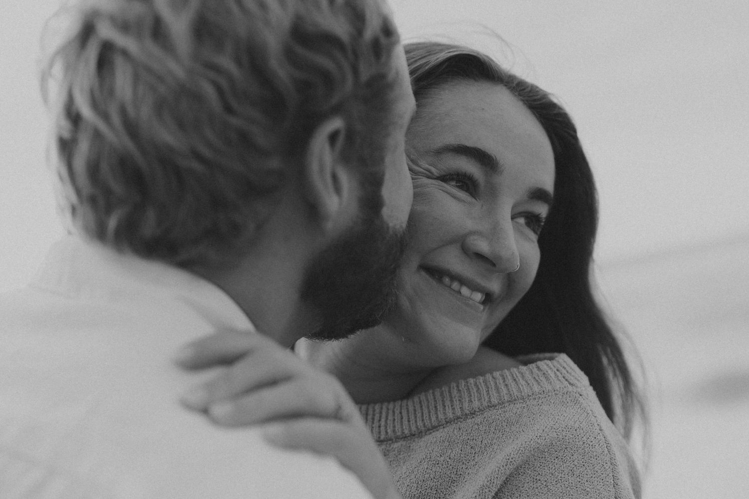 A couple shares an intimate moment in black and white photography.