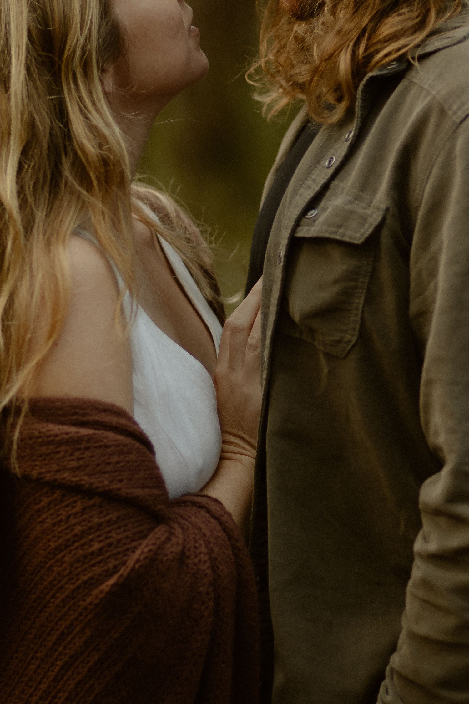 Close-up of couple in casual wear sharing an intimate moment in natural lighting.