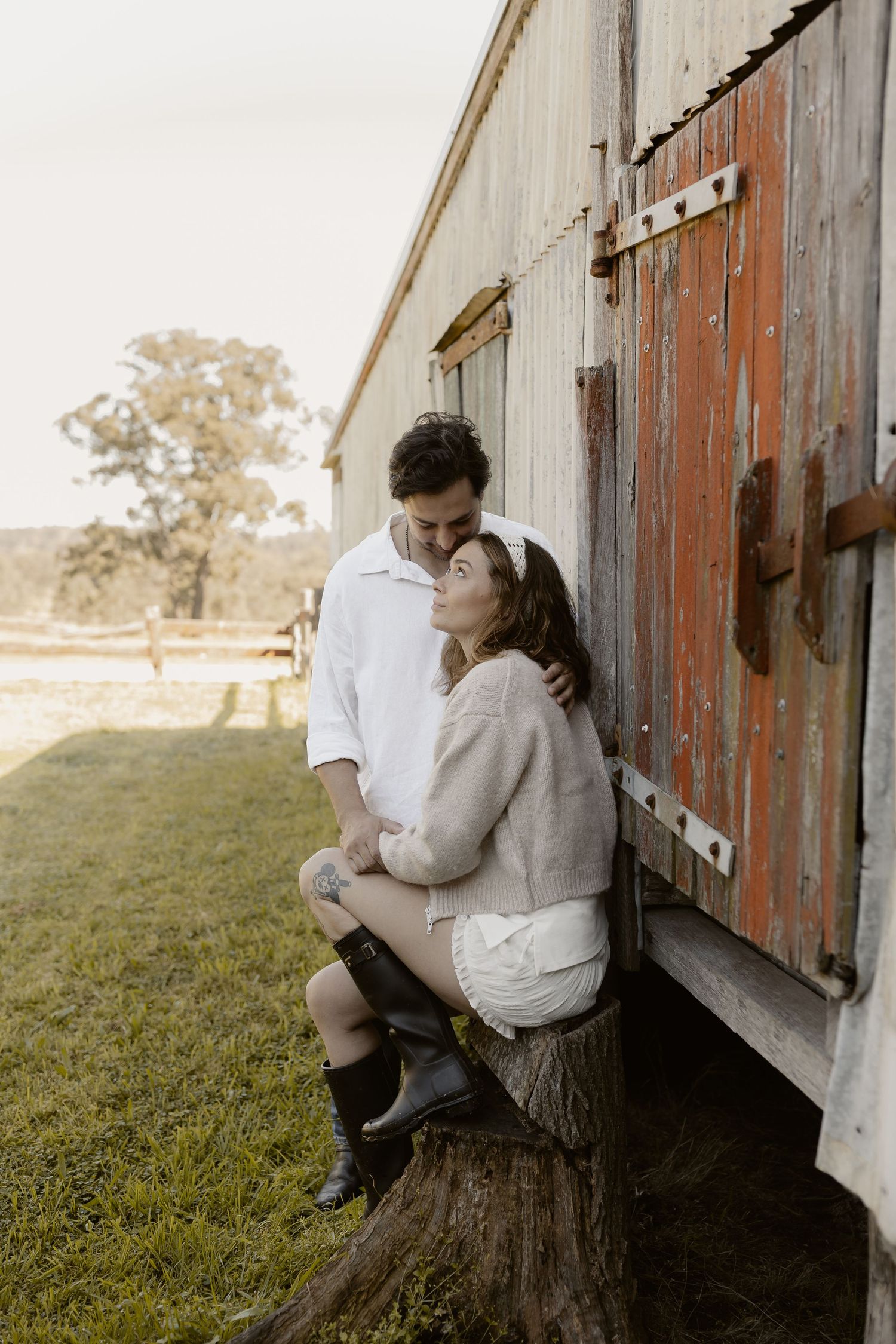 Sweet moments captured outside a rustic barn with wooden details.