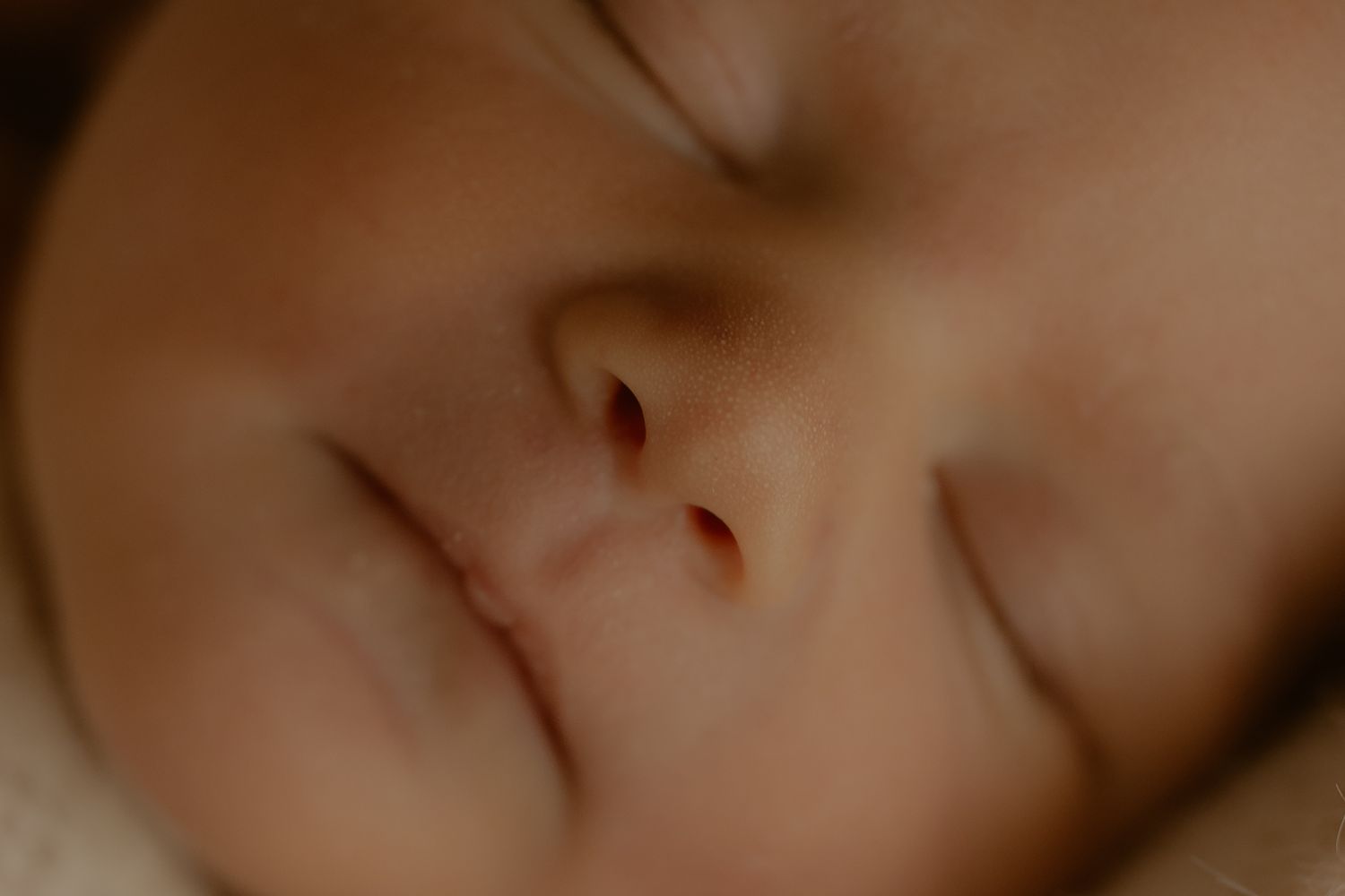 Close-up macro photo of human skin texture showing pores and fine details in warm lighting.