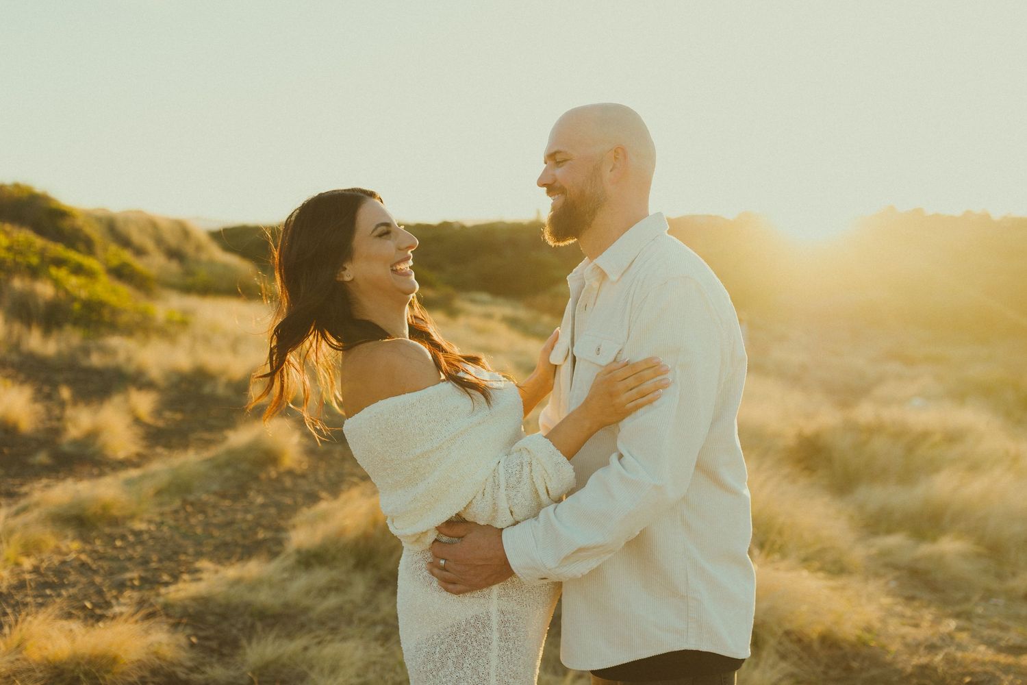 Tender family moment captured in golden light among natural outdoor setting.