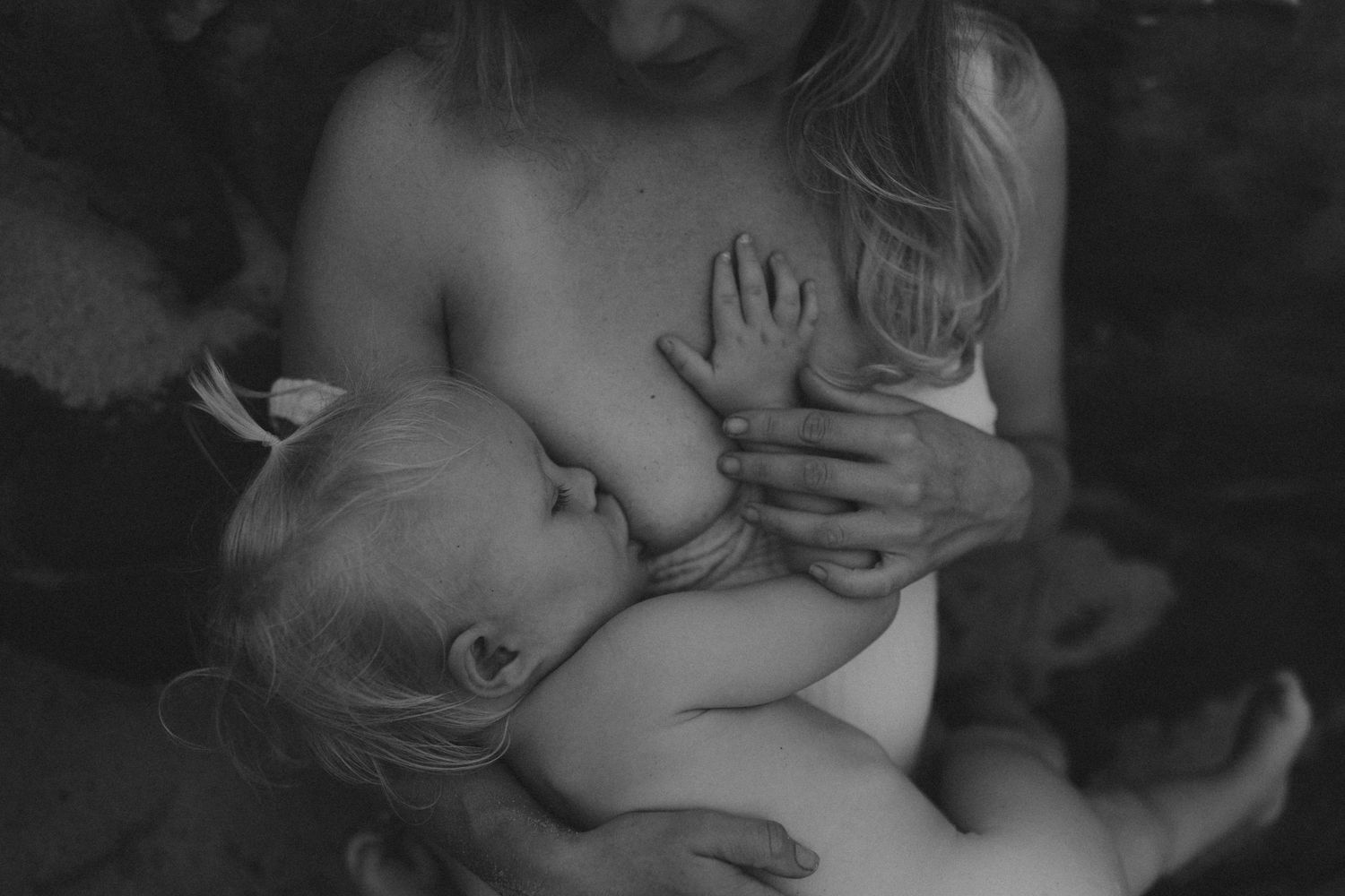 An intimate black and white portrait capturing a tender nursing moment.