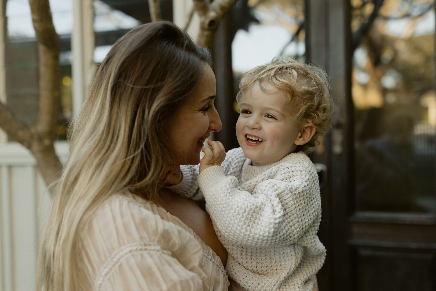 Candid outdoor portrait showing affectionate moment between parent and child.