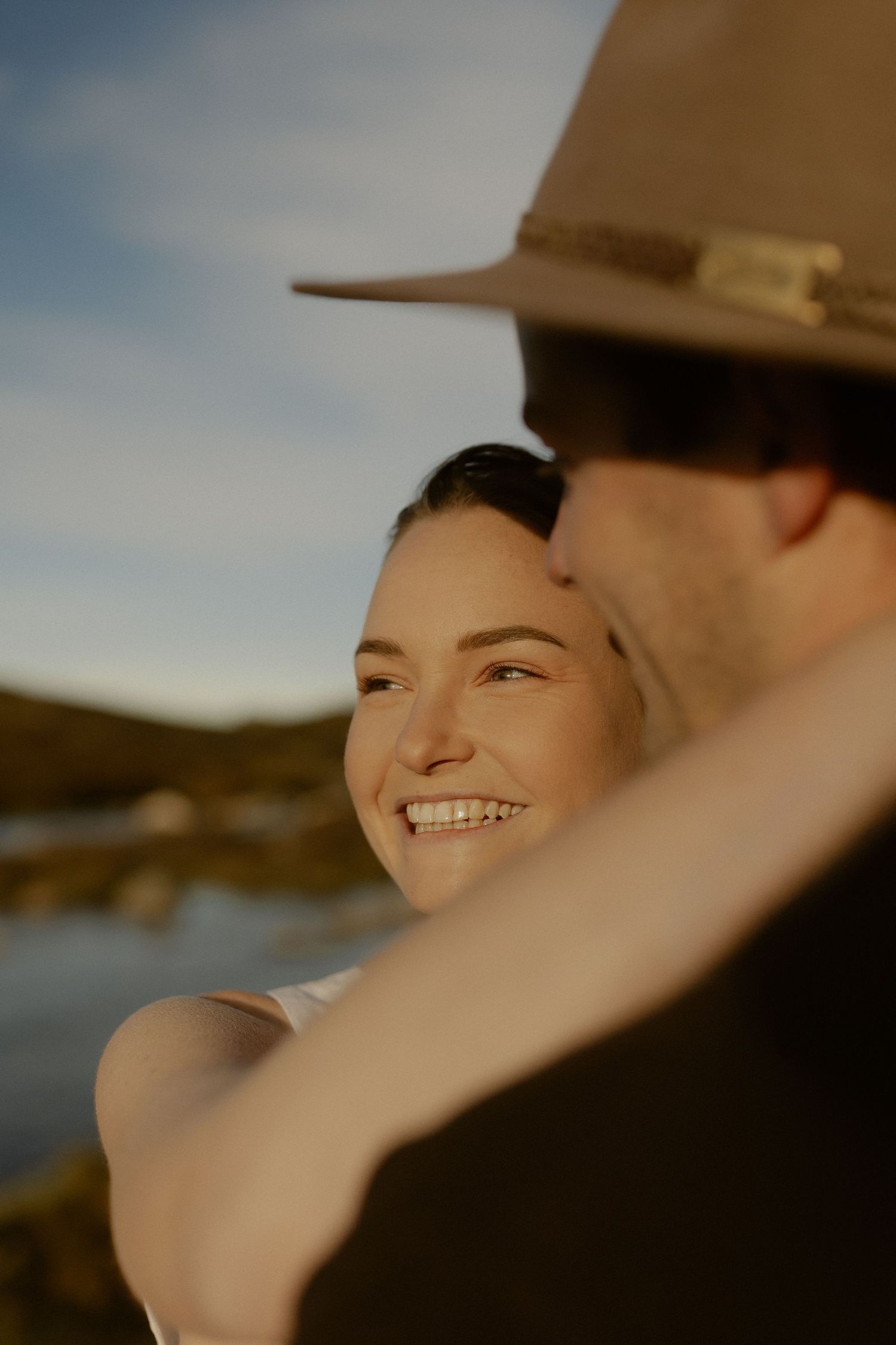 A tender moment captured in warm sunlight as a couple shares an intimate embrace in nature.
