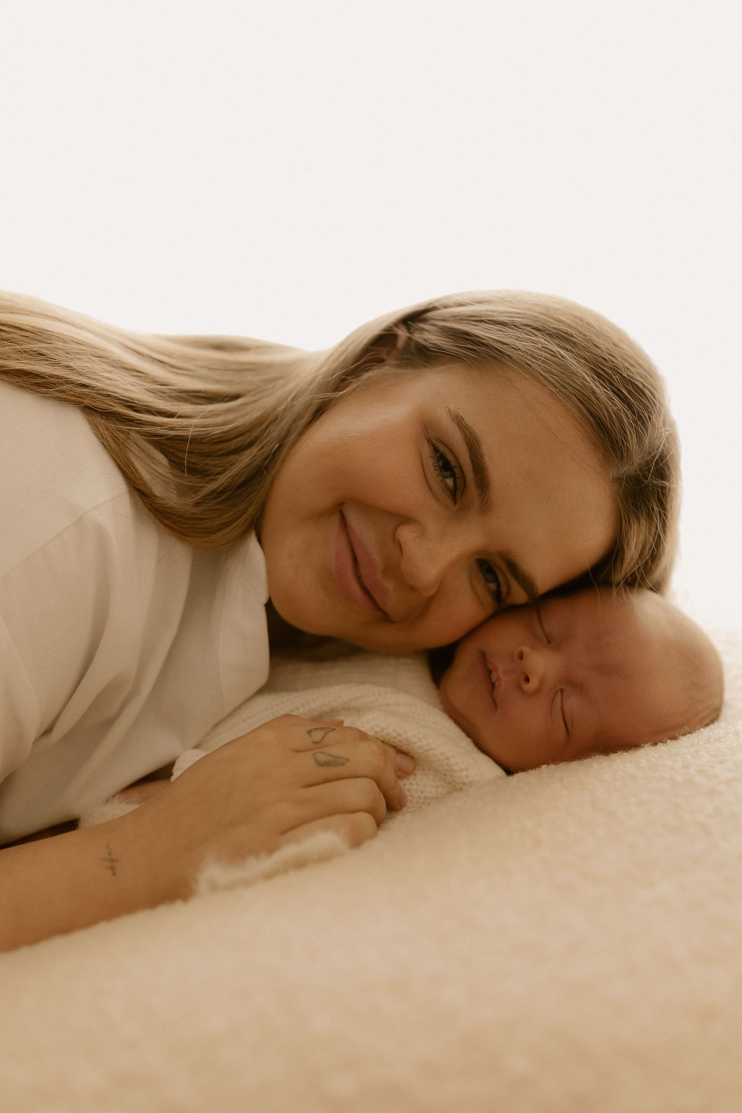 A series of intimate sepia-toned portraits showing someone resting peacefully on white bedding.