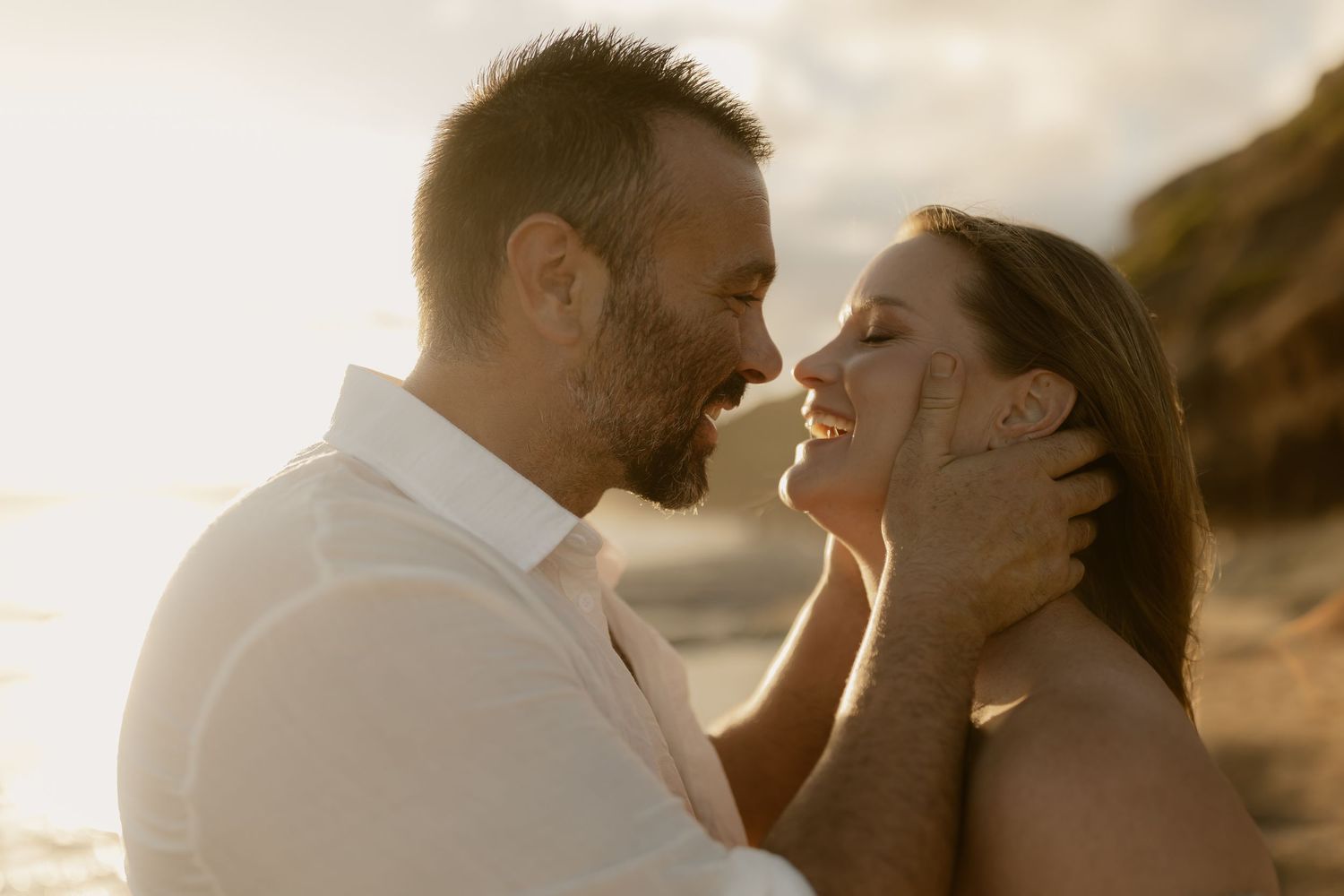 Couple sharing intimate moments at sunset in a romantic outdoor photoshoot series.