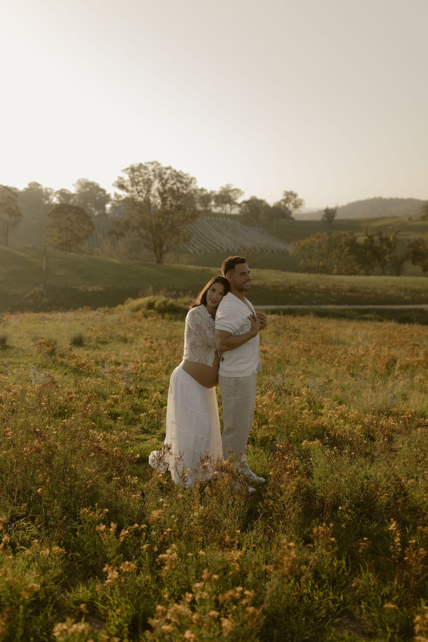 A romantic moment captured in a field of yellow wildflowers during golden hour.